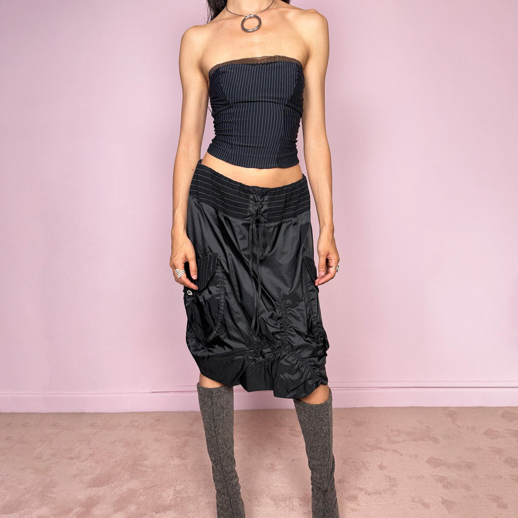 Vintage 2000s black midi skirt with a dark avant-garde parachute-style silhouette, mixed pinstripe panels, ruched construction, oversized utility pockets, tie-front details, elastic waist, and bubble hem. Rare experimental archive piece with dystopian techwear aesthetic by Elisa Cavaletti by Daniela Dallavalle. Can be worn high waisted for L or lower rise for M. Made in Italy from a polyamide polyurethane blend. Great vintage condition.