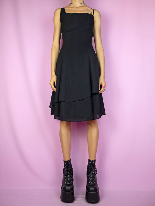 The Vintage 90s Black Asymmetric Layered Dress is an elegant mini dress featuring double straps, intricate rhinestone detailing, and a back zip closure. Perfect for cocktail parties, formal evenings, and night events.
