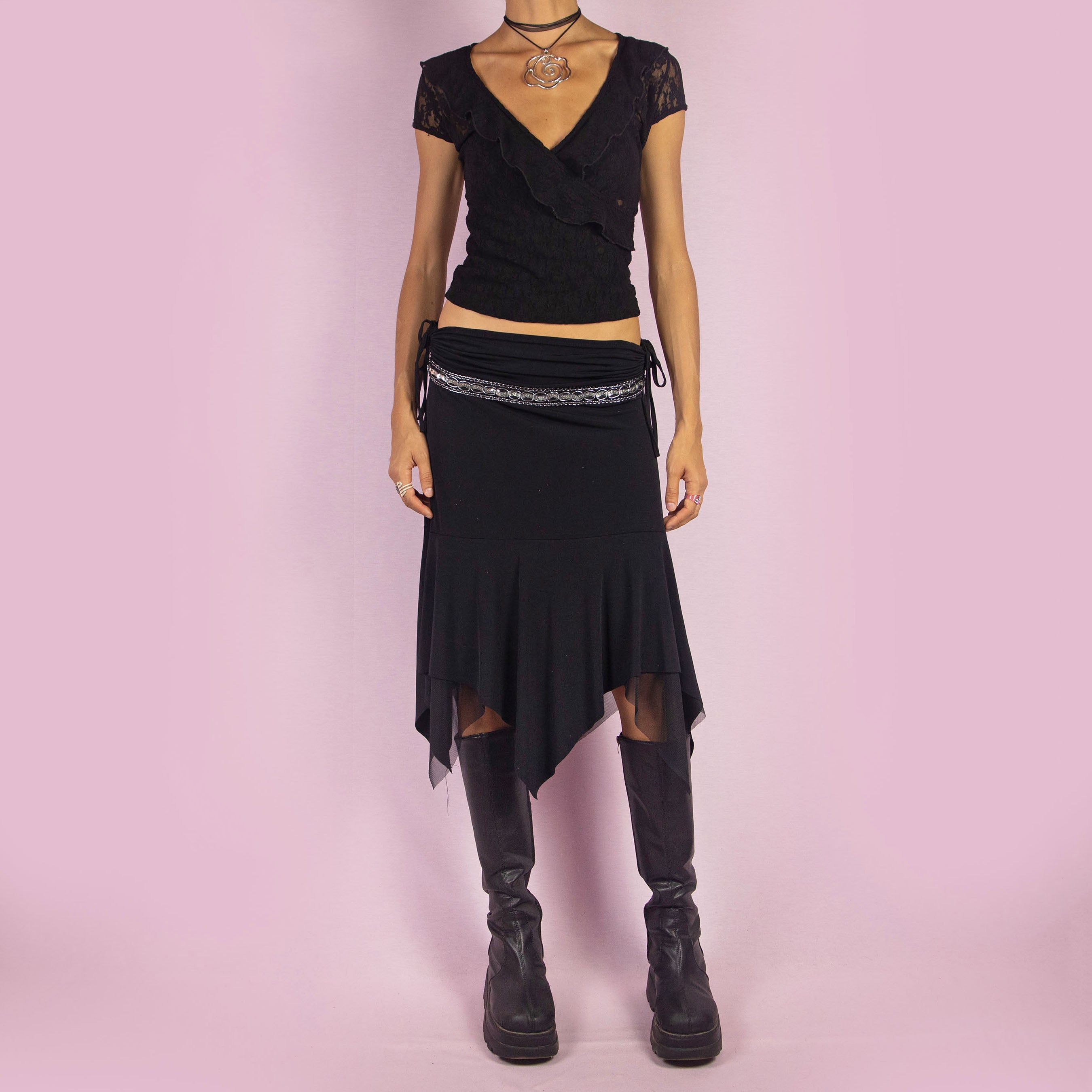 The Y2K Black Layered Asymmetric Skirt is a vintage 2000s piece featuring an avant-garde design. It has intricate bead detailing on the waist and adjustable ruched side ties. The skirt includes mesh sheer layers and a handkerchief-style asymmetric hemline, making it perfect for a bold night out look.