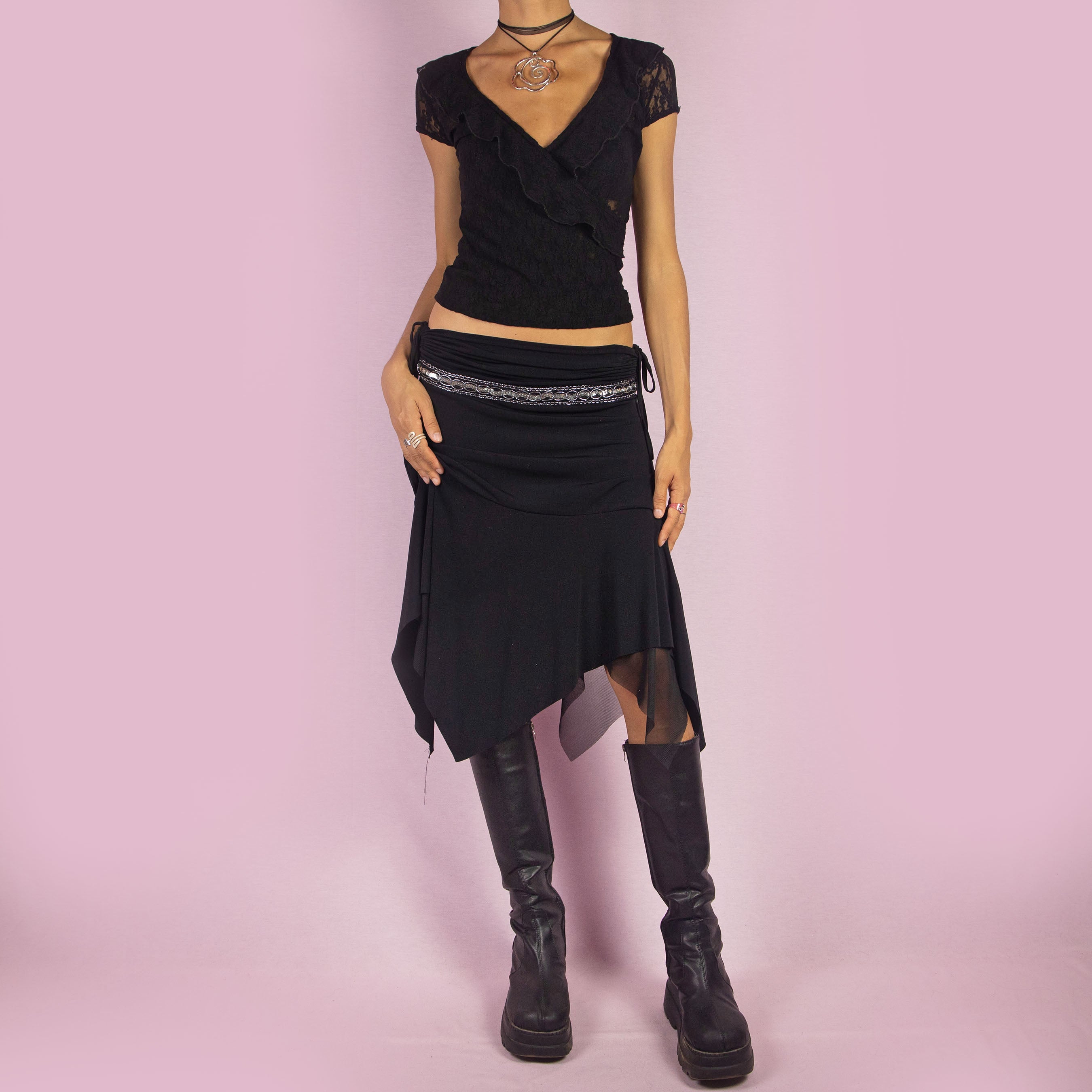 The Y2K Black Layered Asymmetric Skirt is a vintage 2000s piece featuring an avant-garde design. It has intricate bead detailing on the waist and adjustable ruched side ties. The skirt includes mesh sheer layers and a handkerchief-style asymmetric hemline, making it perfect for a bold night out look.
