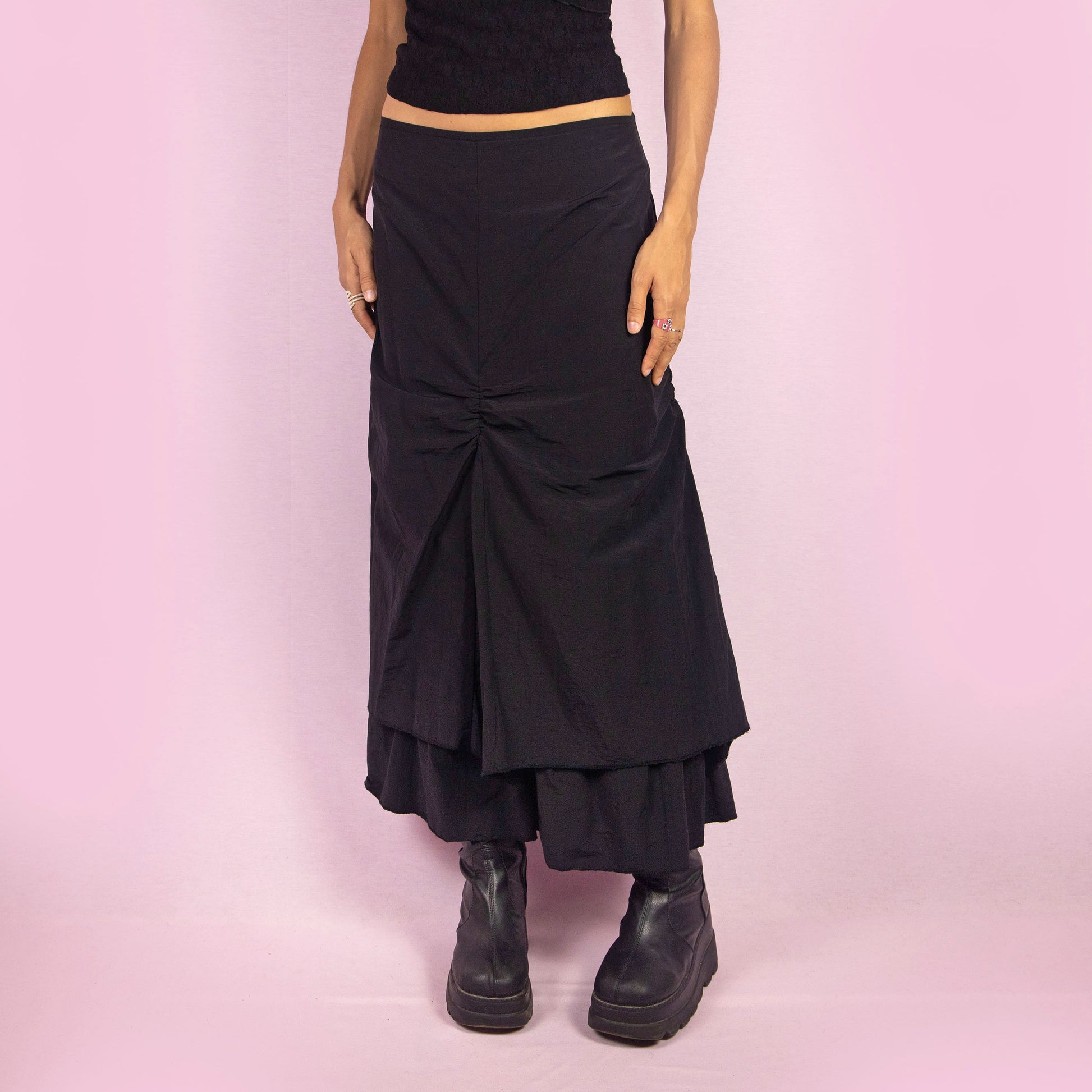 The Y2K Black Layered Midi Skirt is a vintage 2000s piece that features a unique, layered design with ruched details along the front. It includes a back zipper closure and a high-waisted fit. Perfect for both casual and night-out outfits.