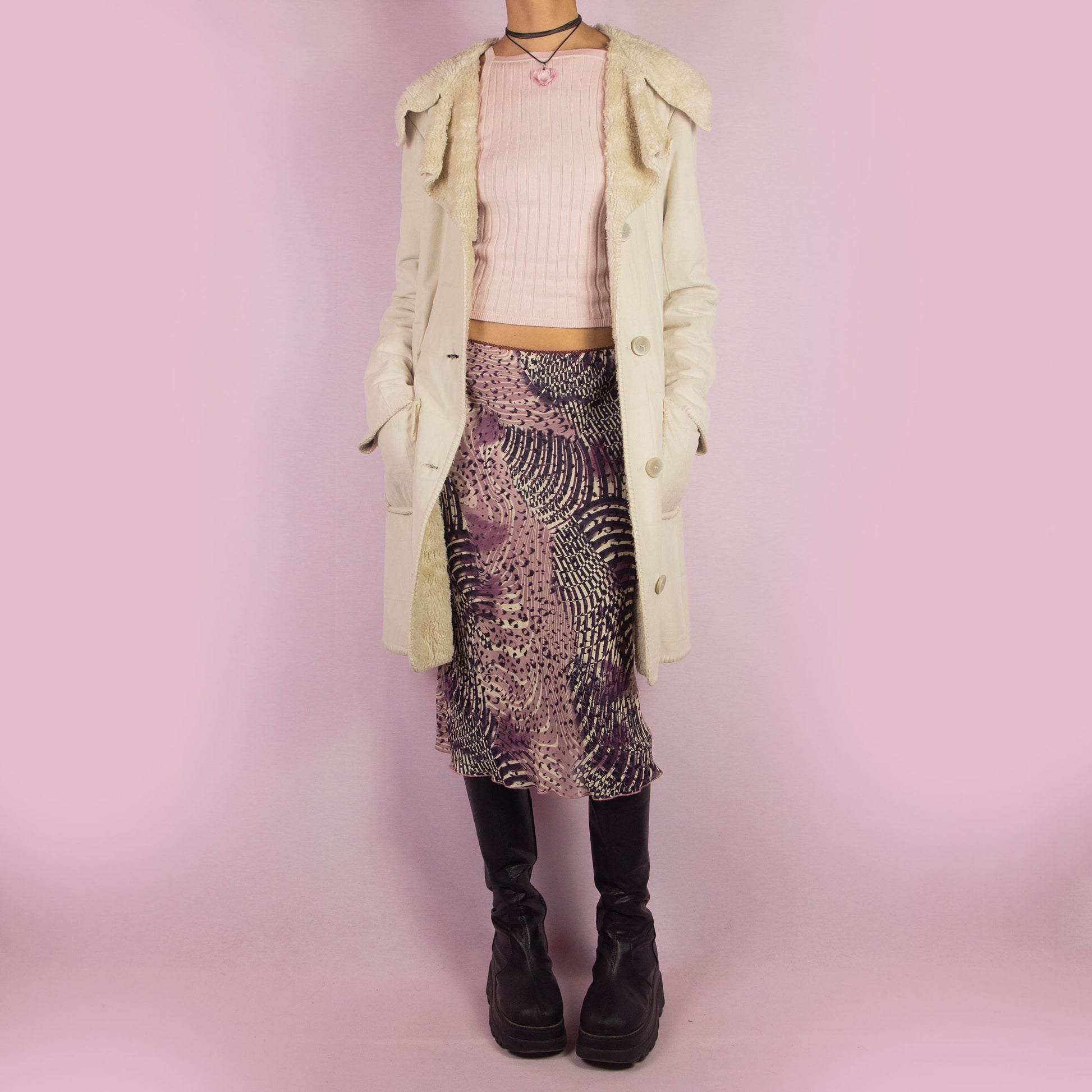 The Y2K Beige Faux Fur Overcoat is a vintage 2000s faux suede longline coat featuring a cozy faux fur collar and trim, large front patch pockets and button closures. Ideal for layering in the winter and any comfy fall outfit.