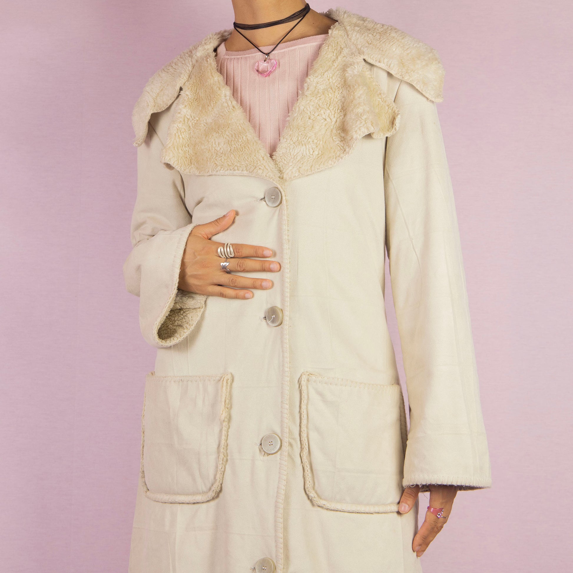 The Y2K Beige Faux Fur Overcoat is a vintage 2000s faux suede longline coat featuring a cozy faux fur collar and trim, large front patch pockets and button closures. Ideal for layering in the winter and any comfy fall outfit.