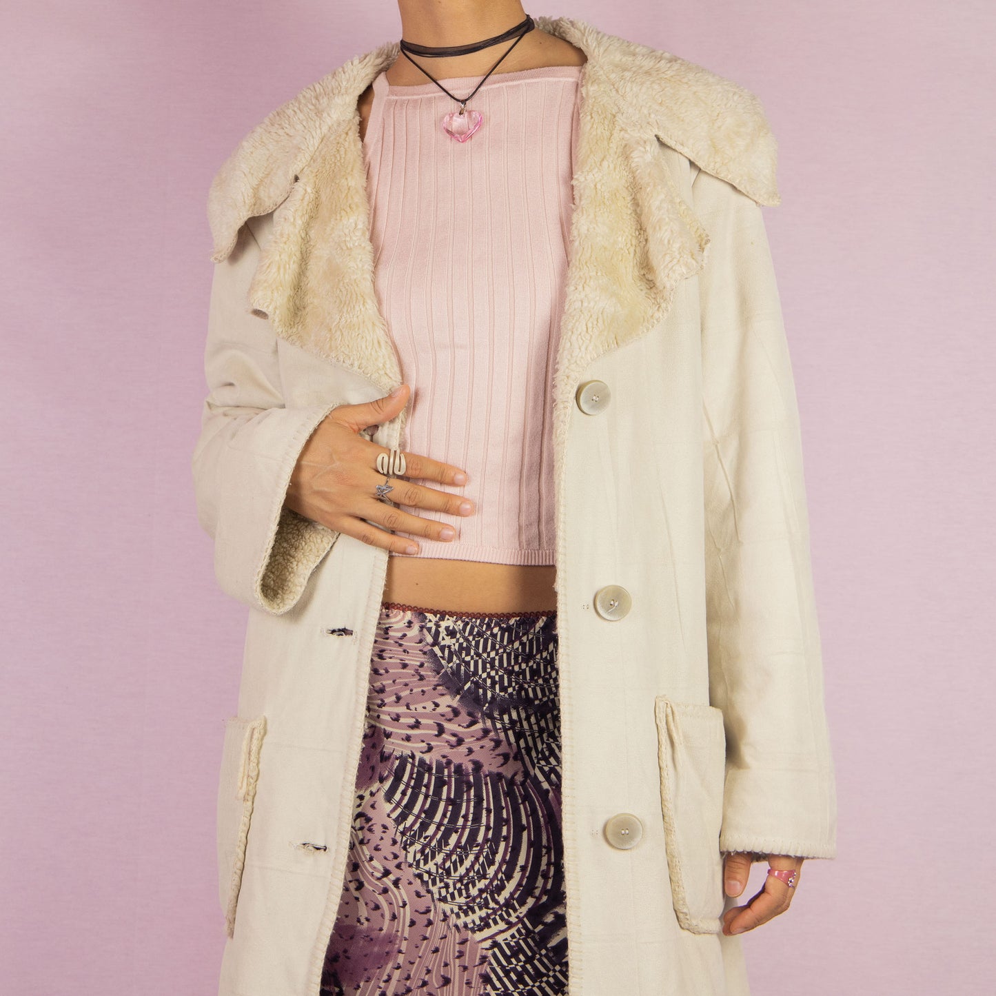 The Y2K Beige Faux Fur Overcoat is a vintage 2000s faux suede longline coat featuring a cozy faux fur collar and trim, large front patch pockets and button closures. Ideal for layering in the winter and any comfy fall outfit.