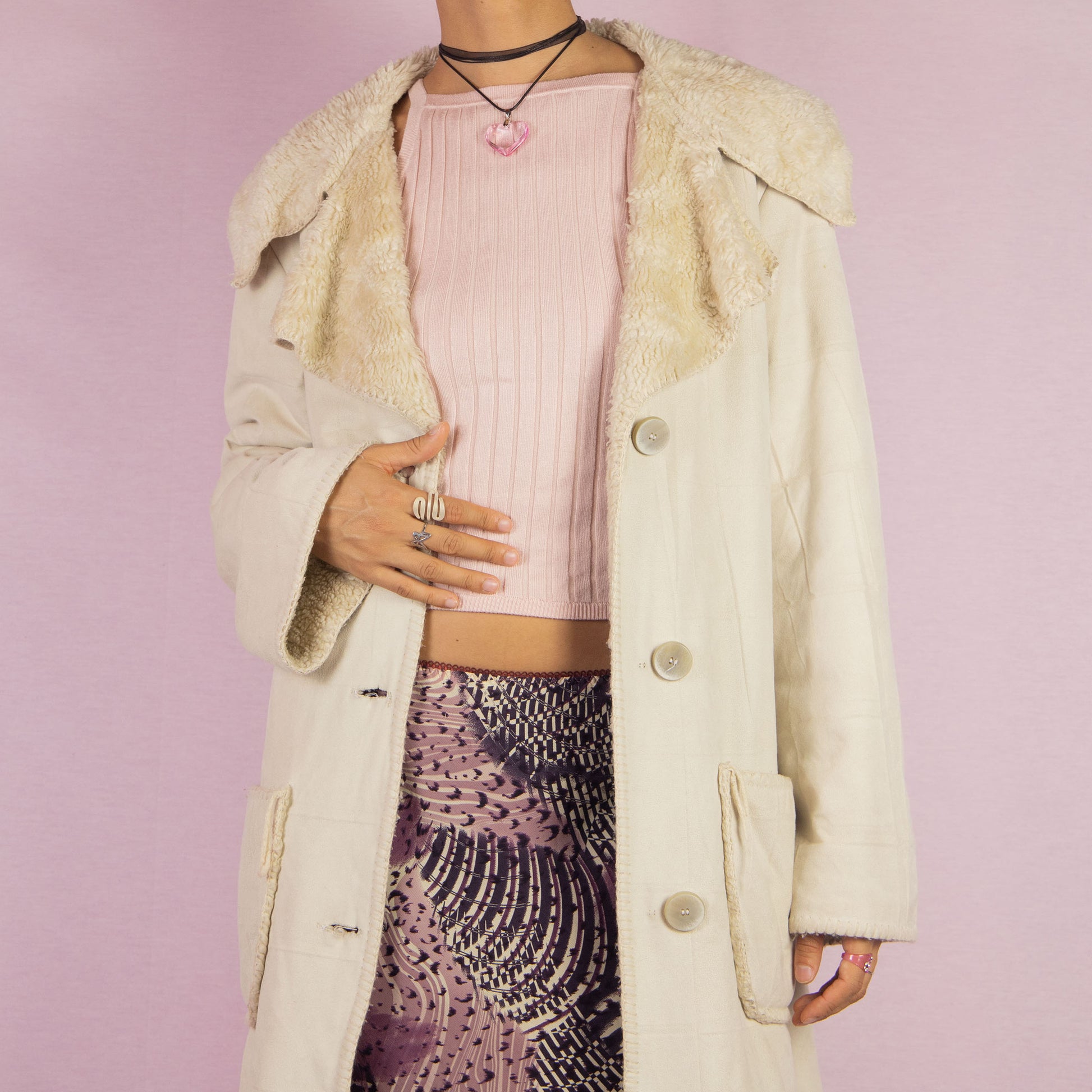 The Y2K Beige Faux Fur Overcoat is a vintage 2000s faux suede longline coat featuring a cozy faux fur collar and trim, large front patch pockets and button closures. Ideal for layering in the winter and any comfy fall outfit.