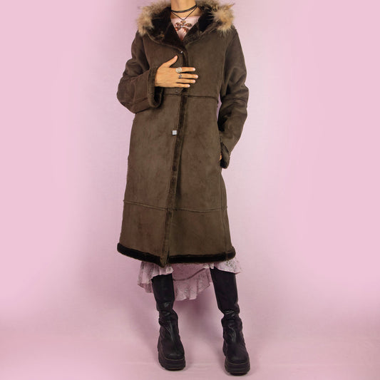 The Y2K Brown Hooded Faux Fur Coat is a cozy vintage 2000s overcoat featuring a soft suede-like fabric with faux fur trim along the hood, cuffs, and hem and it also includes pockets. Ideal for layering in cold weather, it’s perfect for casual winter days or any comfy fall outfit.