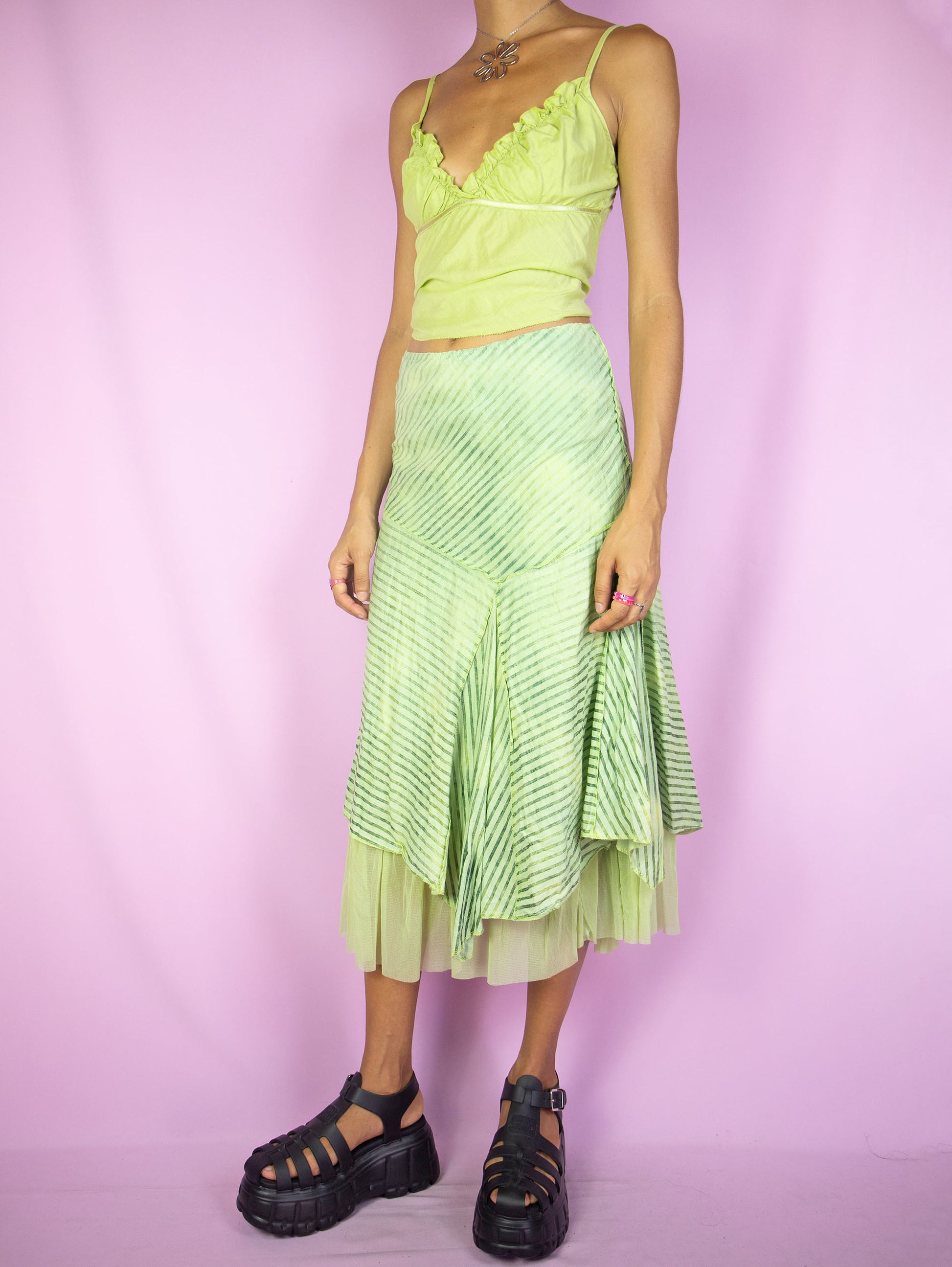 The Y2K Asymmetrical Layered Midi Skirt is a vintage 2000s cyber fairy festival party style green striped print skirt with pointed asymmetric layers, semi-sheer mesh hem and elastic waist.