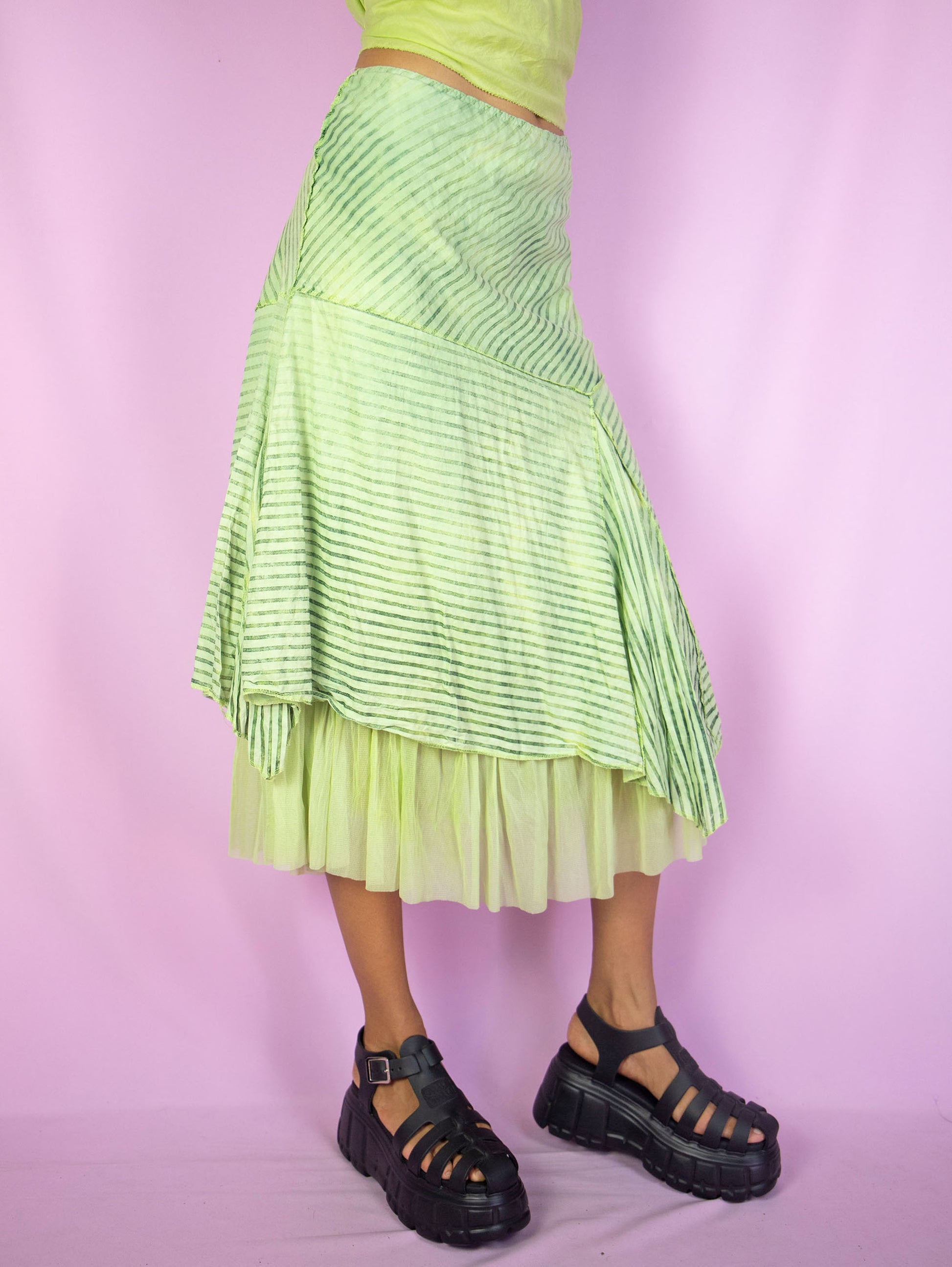 The Y2K Asymmetrical Layered Midi Skirt is a vintage 2000s cyber fairy festival party style green striped print skirt with pointed asymmetric layers, semi-sheer mesh hem and elastic waist.