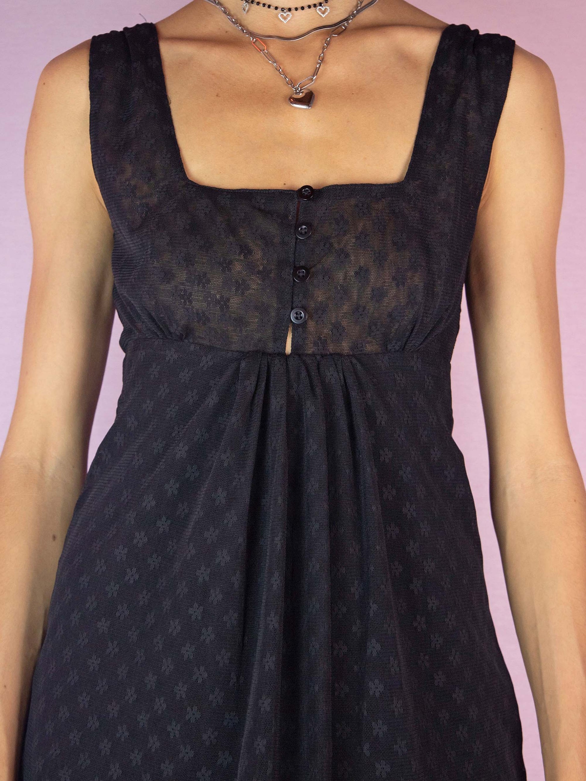 The Y2K Black Mesh Sleeveless Top is a vintage 2000s semi-sheer camisole featuring a square neckline, a button front detail and a pleated front.