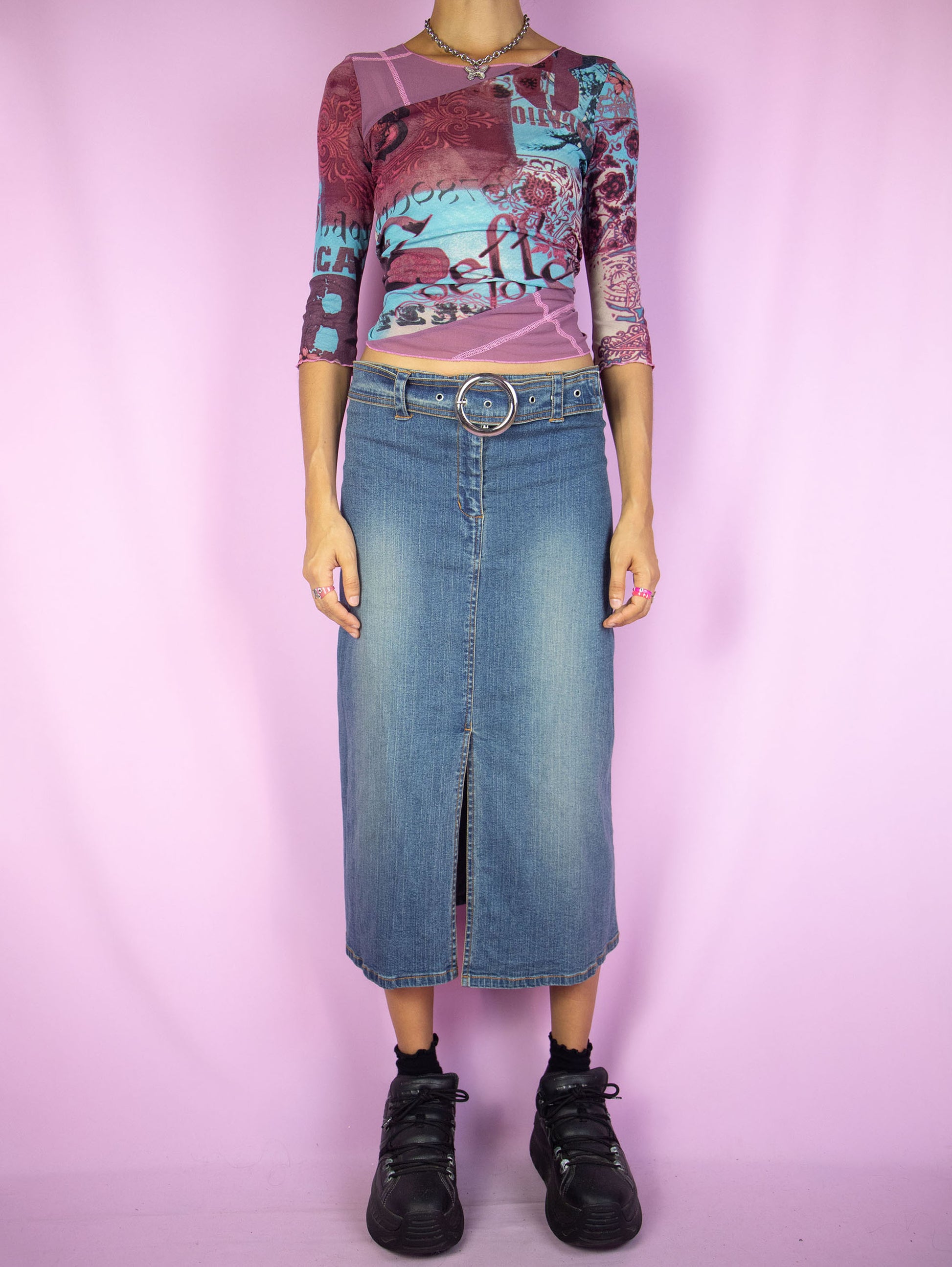 The Y2K Denim Midi Skirt is a vintage 2000s cyber grunge inspired stretchy jean maxi skirt with a front slit, belt buckle and zipper closure.