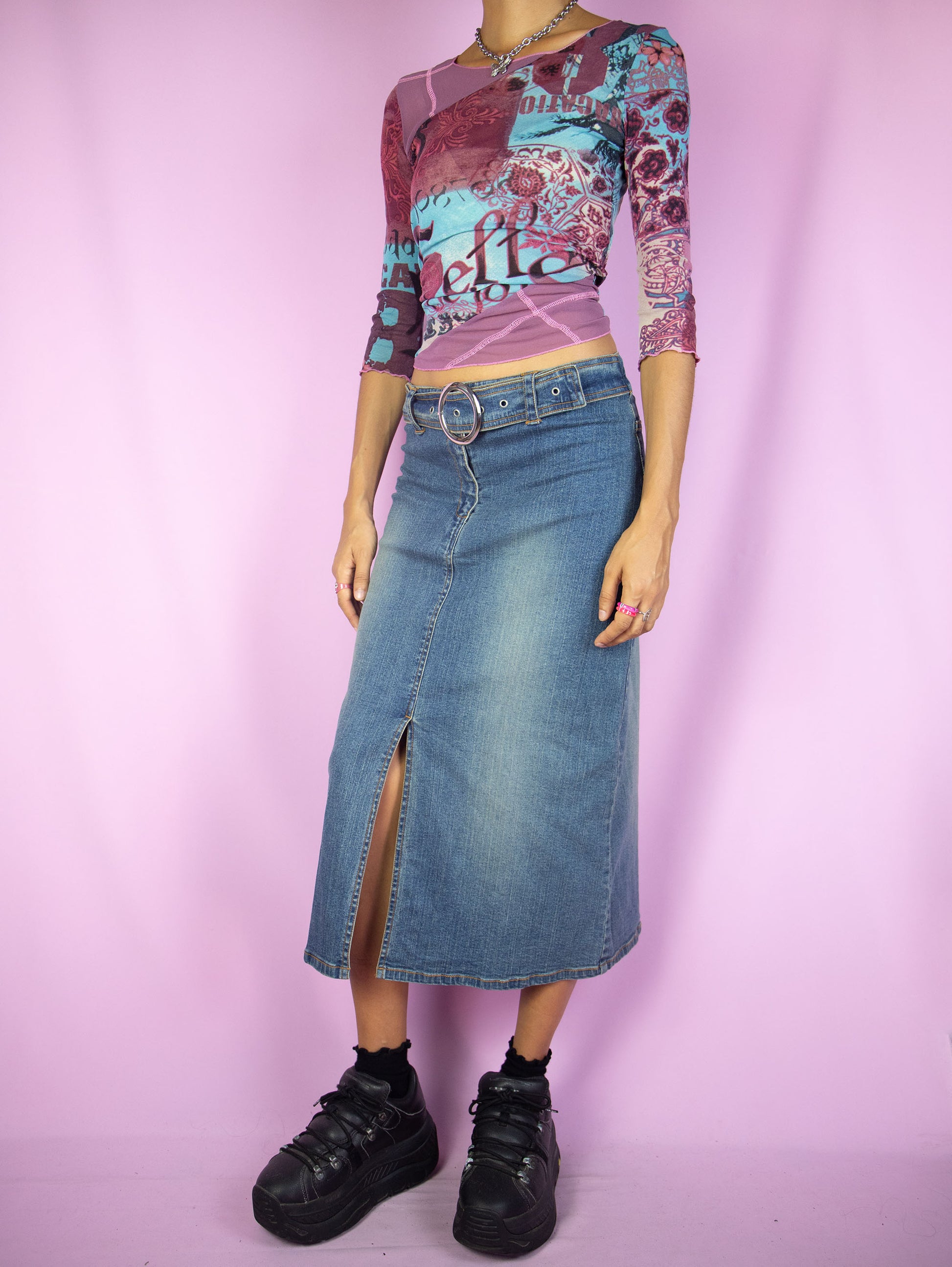 The Y2K Denim Midi Skirt is a vintage 2000s cyber grunge inspired stretchy jean maxi skirt with a front slit, belt buckle and zipper closure.