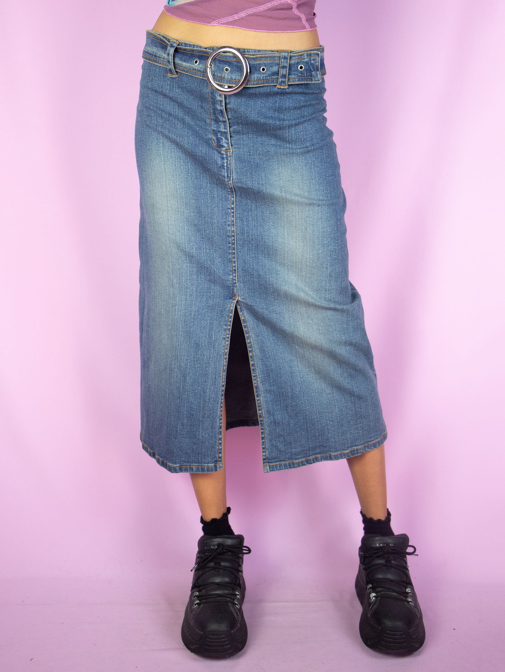 The Y2K Denim Midi Skirt is a vintage 2000s cyber grunge inspired stretchy jean maxi skirt with a front slit, belt buckle and zipper closure.