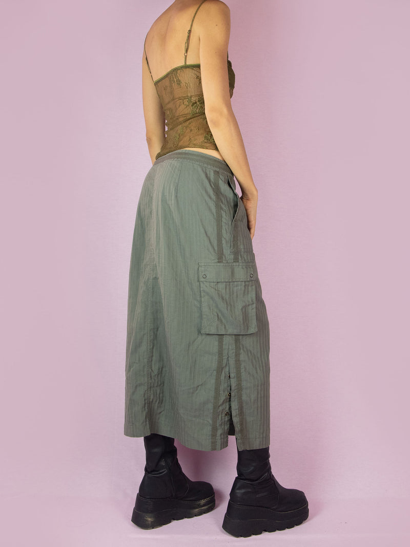 The Y2K Khaki Cargo Midi Skirt is a subversive grunge sporty utility vintage 2000s green striped skirt with pockets, front zipper closure, and side slits with snap buttons.