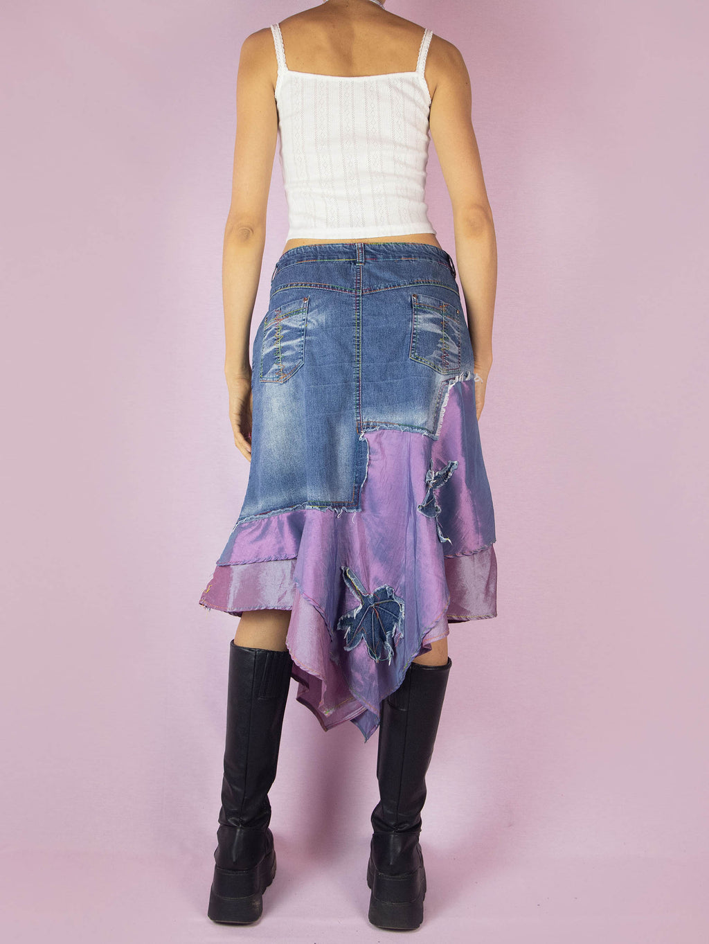 The Y2K Denim Asymmetric Trumpet Skirt is a vintage 2000s slightly stretchy jean midi skirt, avant-garde and deconstructed, with applique and acid wash details, a layered pointed hem, pockets, and a zipper closure.