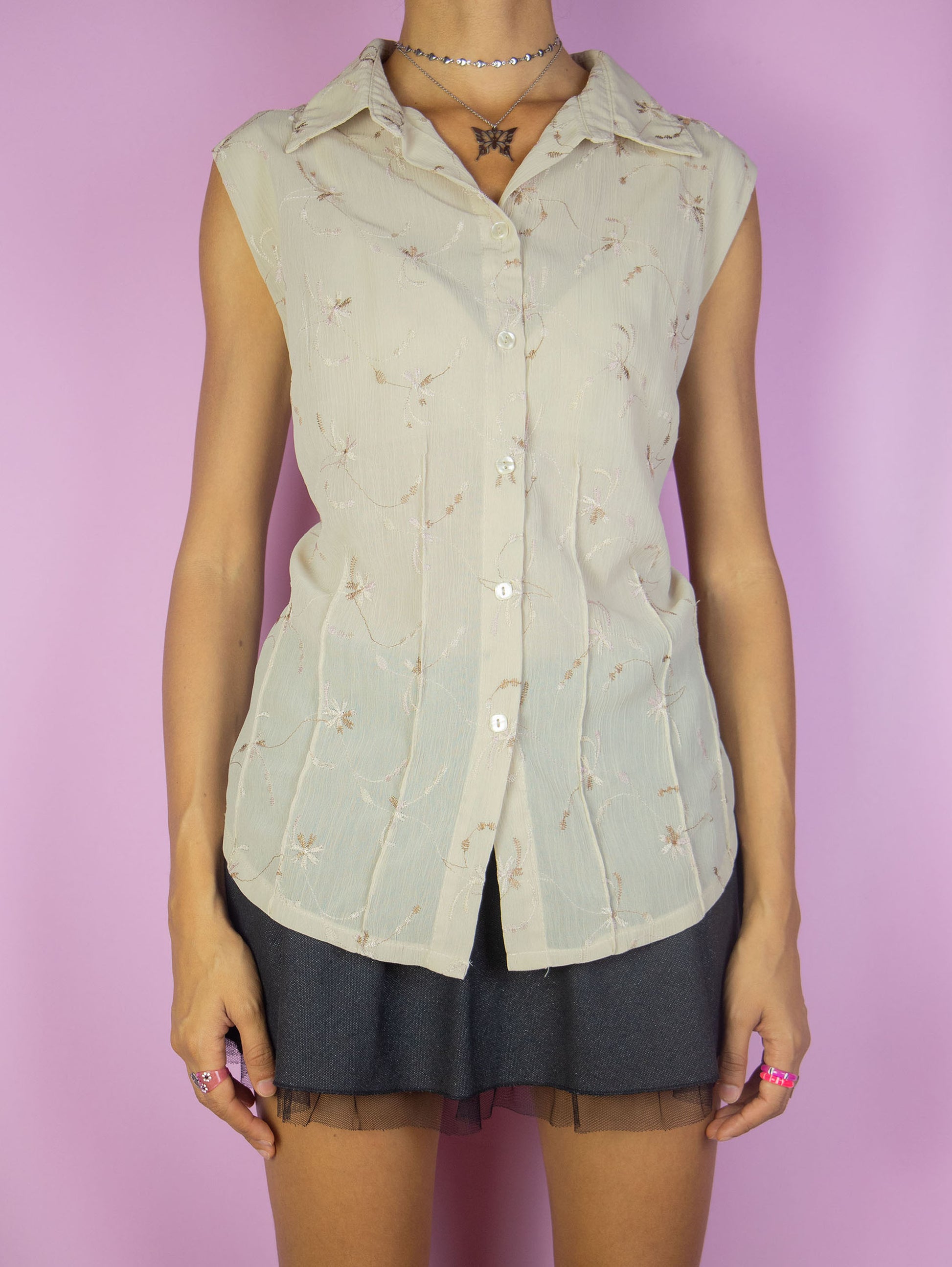 The Vintage 90s Beige Sleeveless Blouse is a lightweight top featuring light brown floral embroidery details and a button-up front. Perfect for a casual summer day Excellent vintage condition.