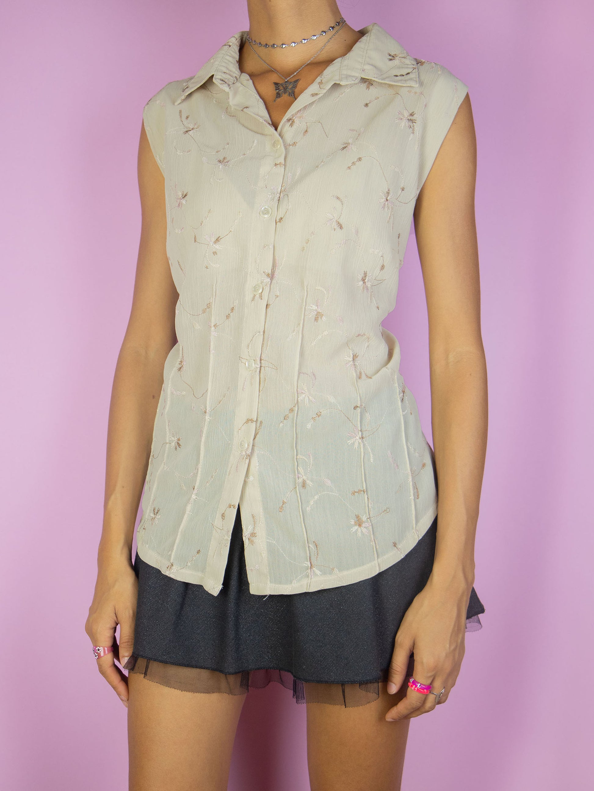 The Vintage 90s Beige Sleeveless Blouse is a lightweight top featuring light brown floral embroidery details and a button-up front. Perfect for a casual summer day Excellent vintage condition.