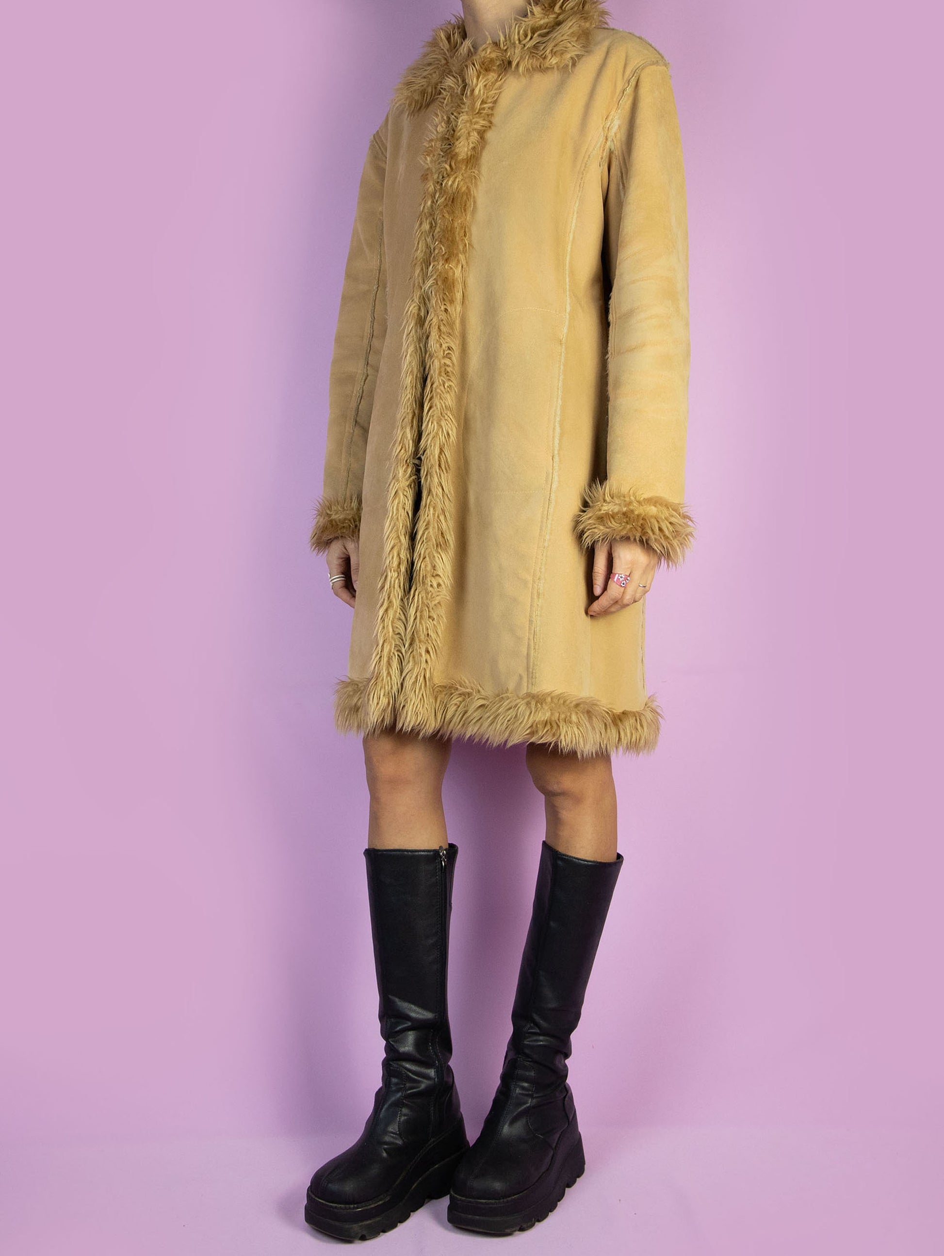 The Y2K Penny Lane Beige Coat is a vintage light brown beige faux suede coat with faux fur interior, collar, and cuffs. It also has pockets and a hook closure. Boho fairy grunge 2000s afghan-inspired winter statement jacket.