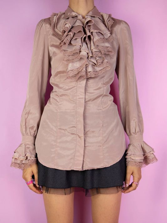 The Vintage 90s Pink Ruffle Blouse is a refined dusty pink top with a classic frill collar and button front, embellished with soft ruffles and subtle lace detail around the neck and wrists. Perfect for classy outfits.