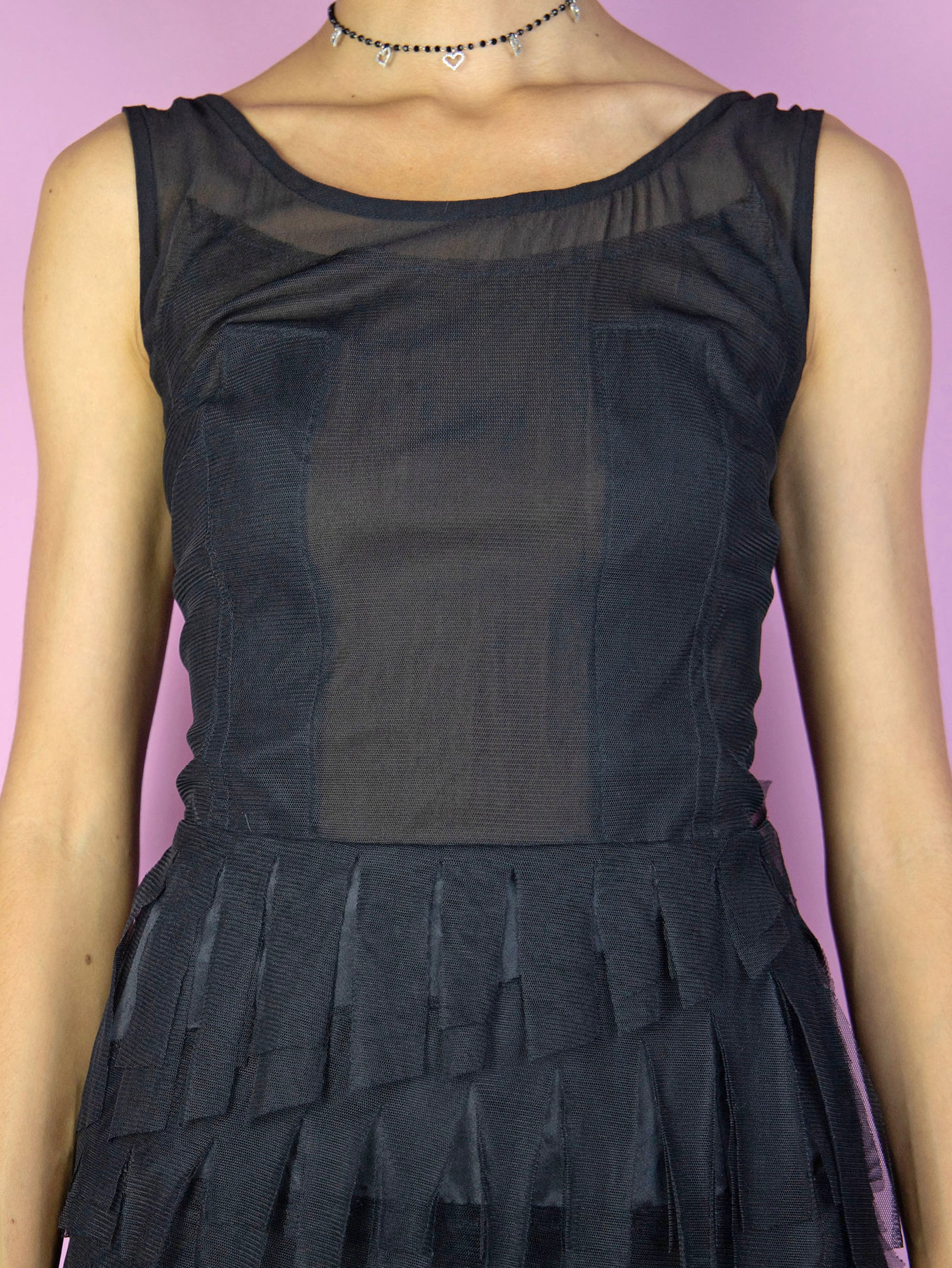 The Y2K Black Mesh Mini Dress is a vintage black fringe dress with semi-sheer mesh details and a side zipper closure. Cyber goth 2000s avant garde party night mini dress.