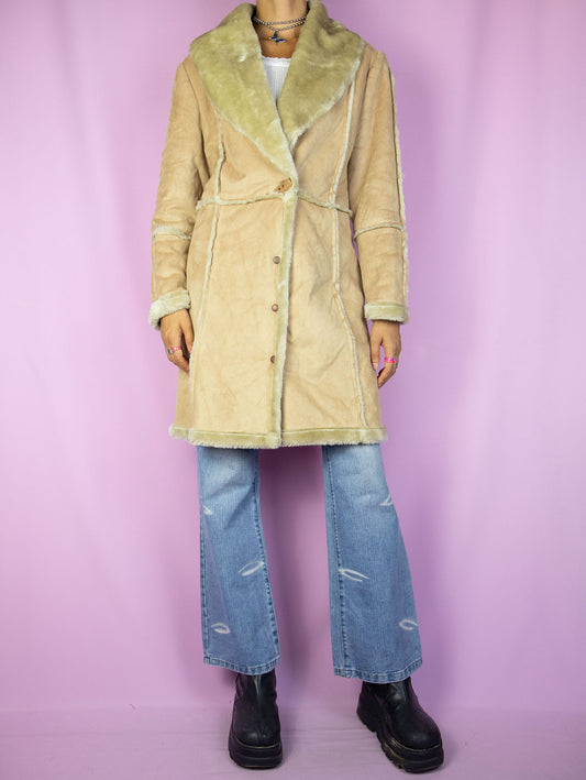 The Y2K Faux Suede Beige Coat is a vintage 2000s winter overcoat made from faux suede, featuring a cozy faux fur lining, a V-neck, and a snap-button closure. Perfect for a casual and warm winter outfit.
