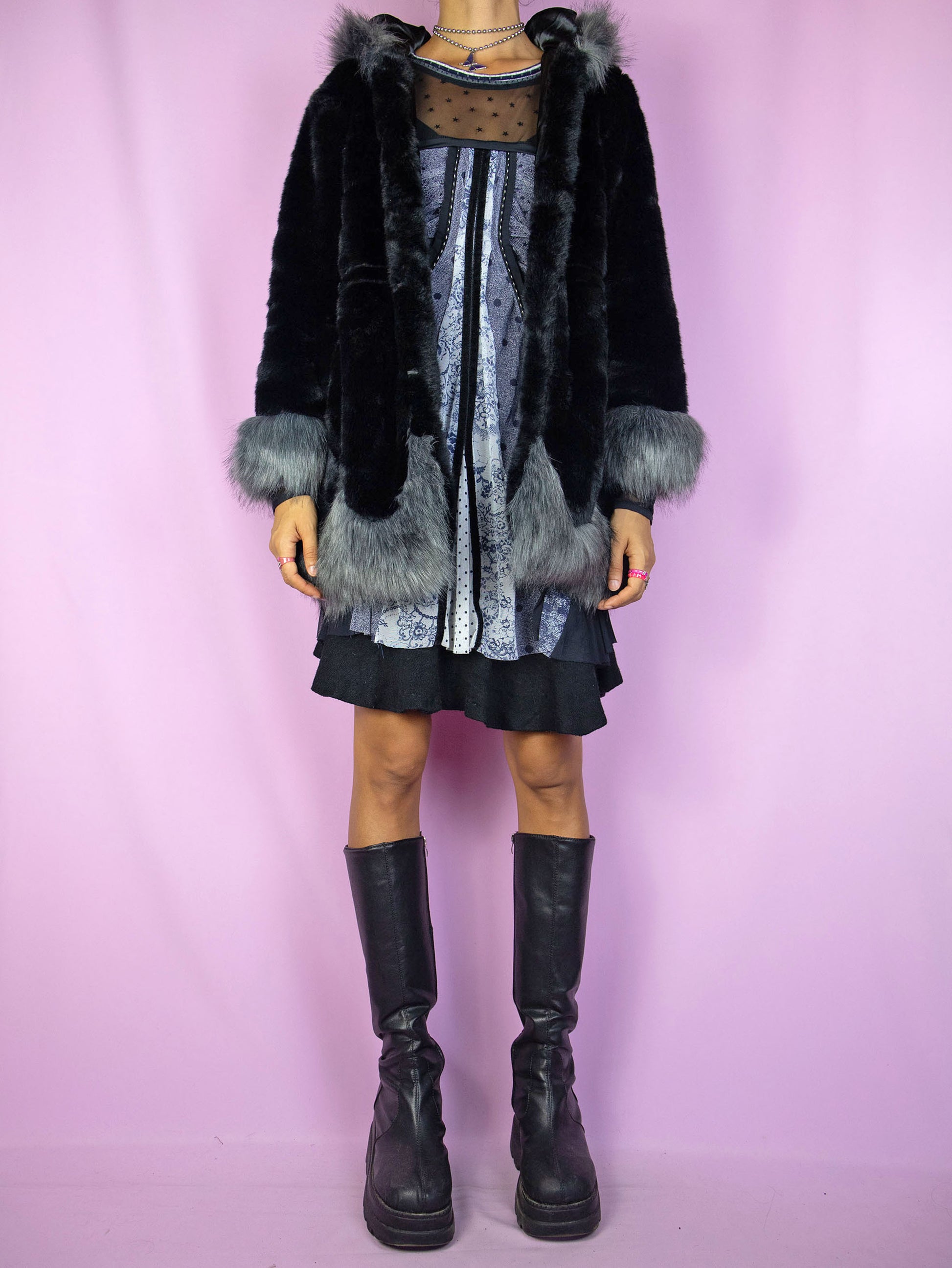 The Y2K Black Faux Fur Jacket is a vintage black faux fur jacket with gray details, a hood, pockets, and hook closure. A cute dark fairy goth winter statement coat from the 2000s.