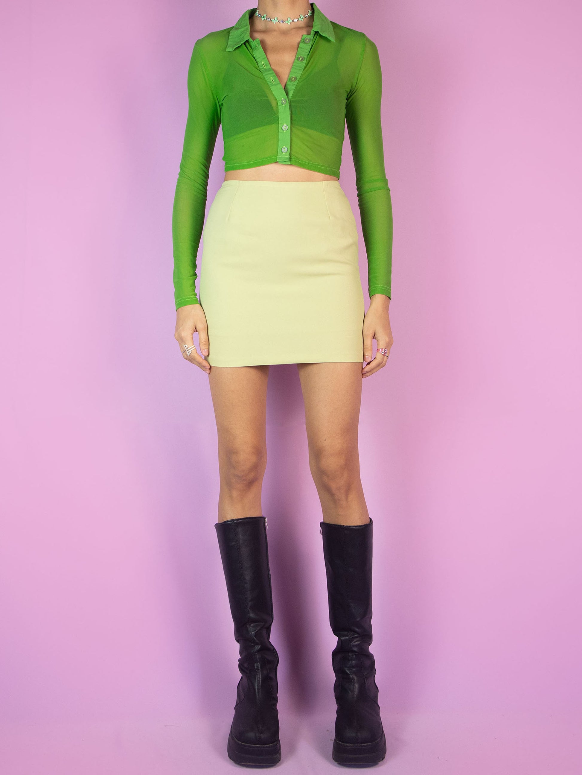The Vintage 90s Green Tailored Mini Skirt is a light yellowish-green pencil skirt featuring a high-waisted, tailored fit and a back zipper closure. Perfect for formal events.