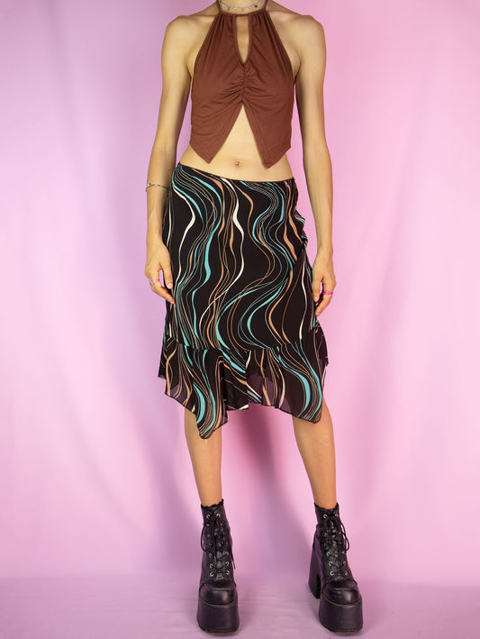 The Y2K Brown Print Trumpet Skirt is a vintage 2000s midi skirt that features an abstract wavy pattern in multicolor shades on a dark brown background, an asymmetric hemline with pointed edges and ruffle details, as well as an elastic waistband. Perfect for casual outings and summer events.