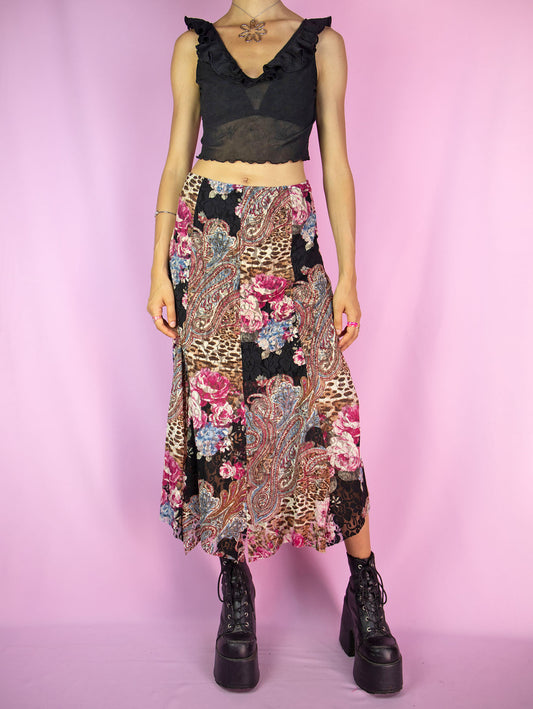 The Y2K Lace Mesh Midi Skirt is a vintage 2000s skirt featuring an abstract floral and paisley patchwork design. Crafted from semi-sheer mesh fabric with lace details, it has an elastic waist and a spliced hem. This skirt is perfect for summer parties and boho-inspired outfits.