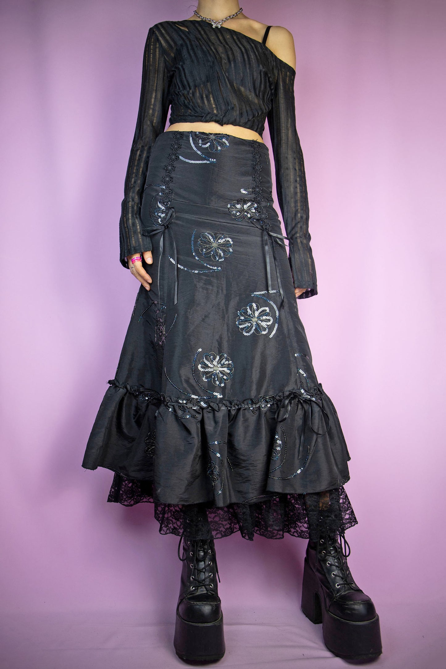 The Vintage 90s Black Trumpet Midi Skirt features a fitted waist that flares out into a trumpet silhouette, intricate sequin floral embroidery and ruffle lace details at the hem, and a side zipper closure. Perfect for a formal night party or elegant event. Excellent vintage condition.