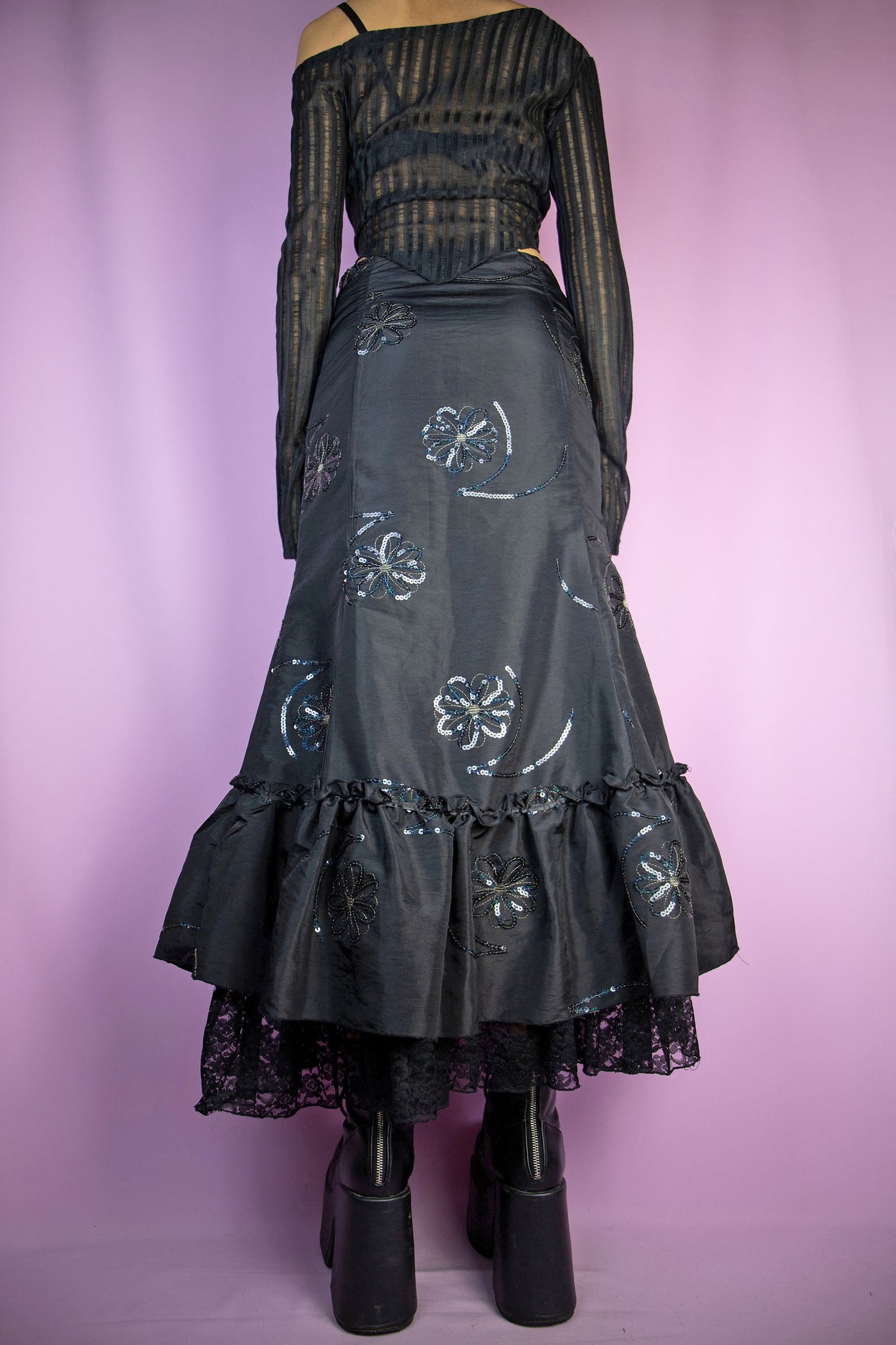 The Vintage 90s Black Trumpet Midi Skirt is an embellished skirt adorned with sequin details, bows, a ruffled hem, and a side zipper closure. Elegant fairy goth 1990s evening party maxi skirt.