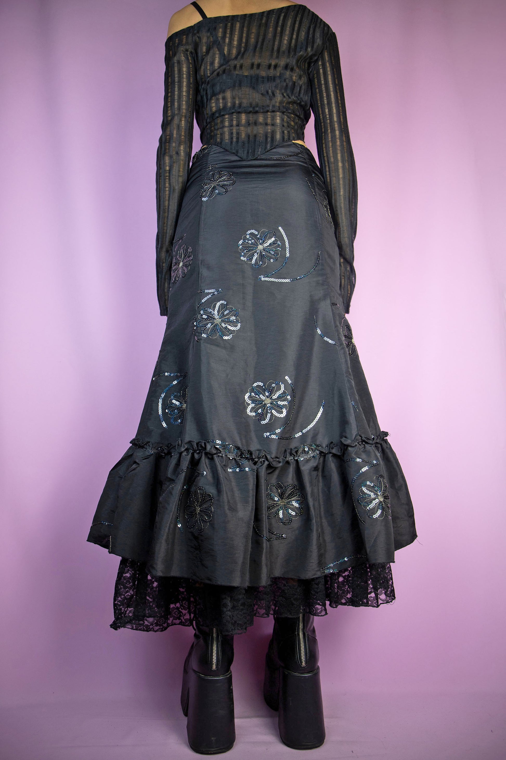 The Vintage 90s Black Trumpet Midi Skirt is an embellished skirt adorned with sequin details, bows, a ruffled hem, and a side zipper closure. Elegant fairy goth 1990s evening party maxi skirt.