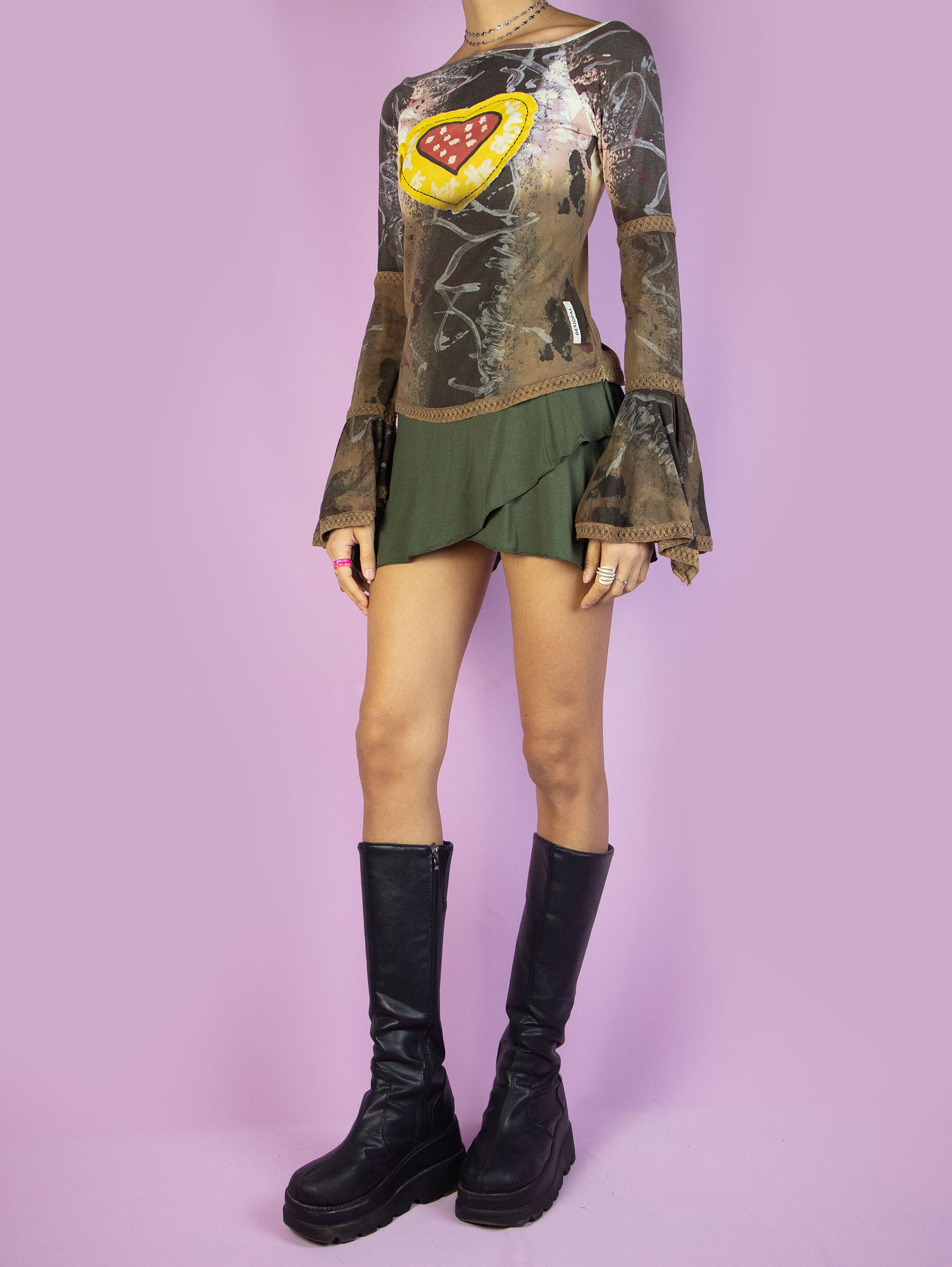The Y2K Desigual Brown Bell Sleeve Top is a multicolored graphic brown shirt with an abstract print, long bell sleeves, and a heart-shaped patchwork-style detail. Cyber avant garde 2000s subversive top.