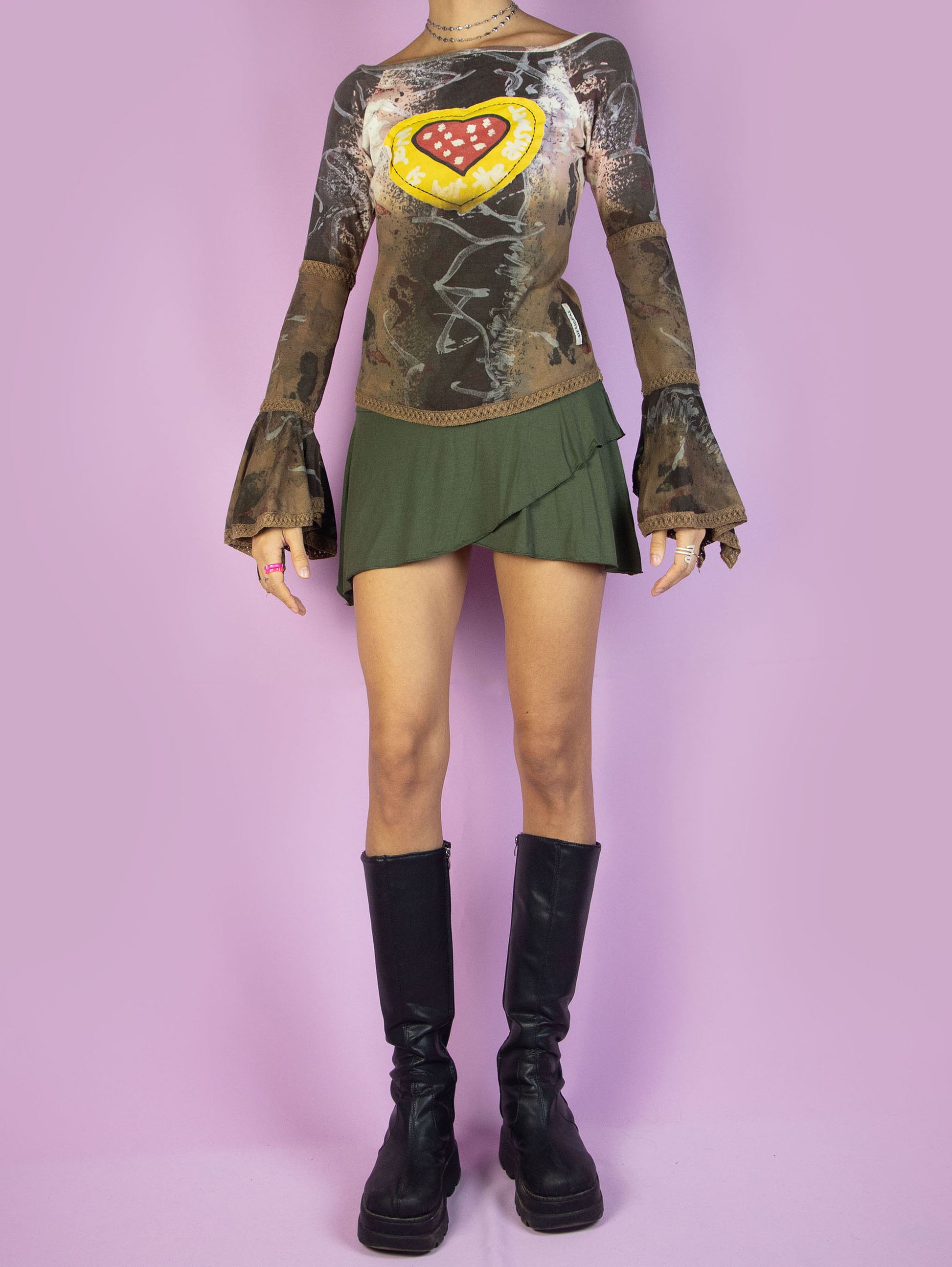 The Y2K Desigual Brown Bell Sleeve Top is a multicolored graphic brown shirt with an abstract print, long bell sleeves, and a heart-shaped patchwork-style detail. Cyber avant garde 2000s subversive top.