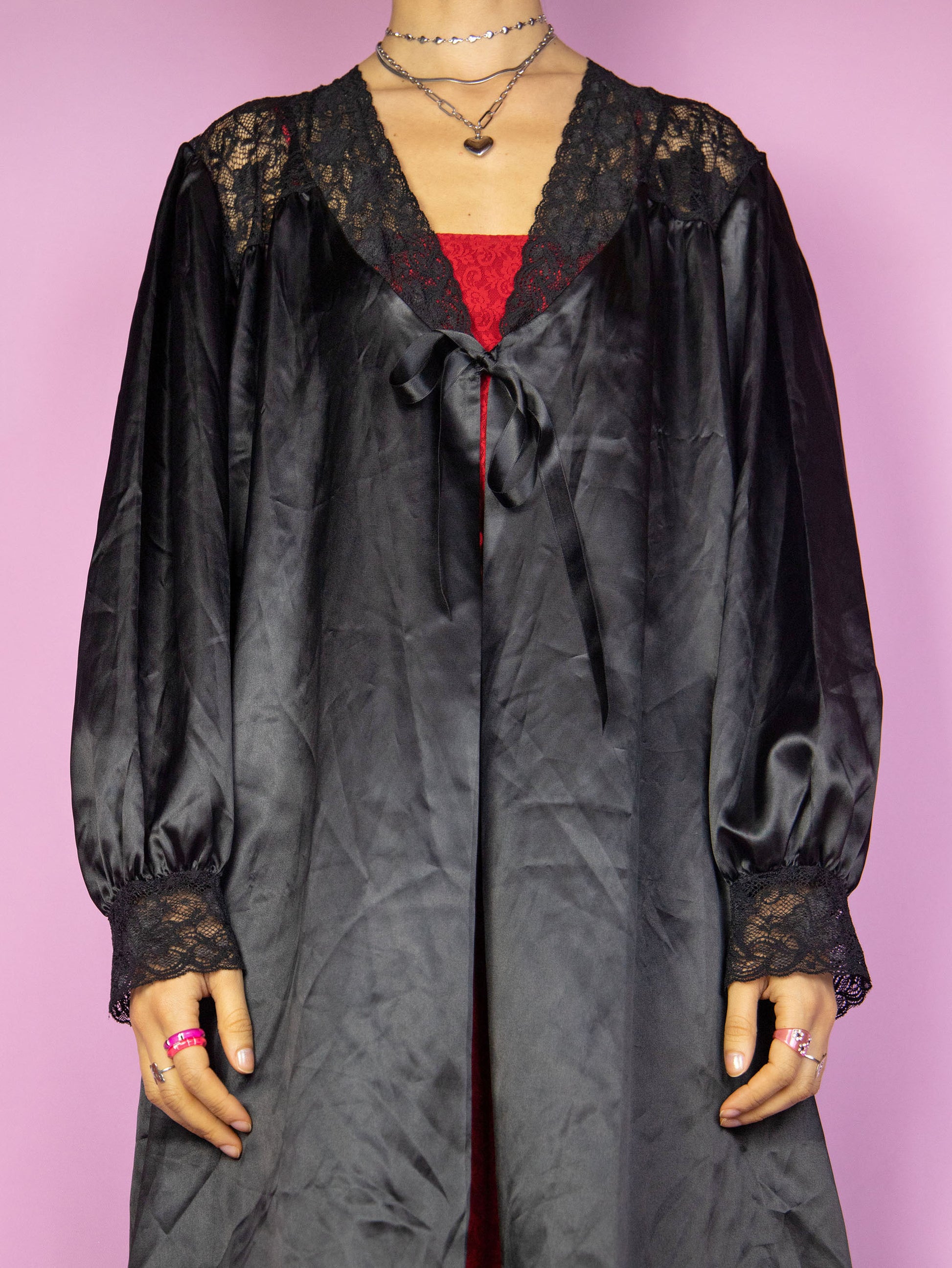 The Vintage 90s Black Satin Duster Jacket is a shiny balloon sleeve tie-front robe peignoir lounge sleepwear with lace details. Made in Spain.
