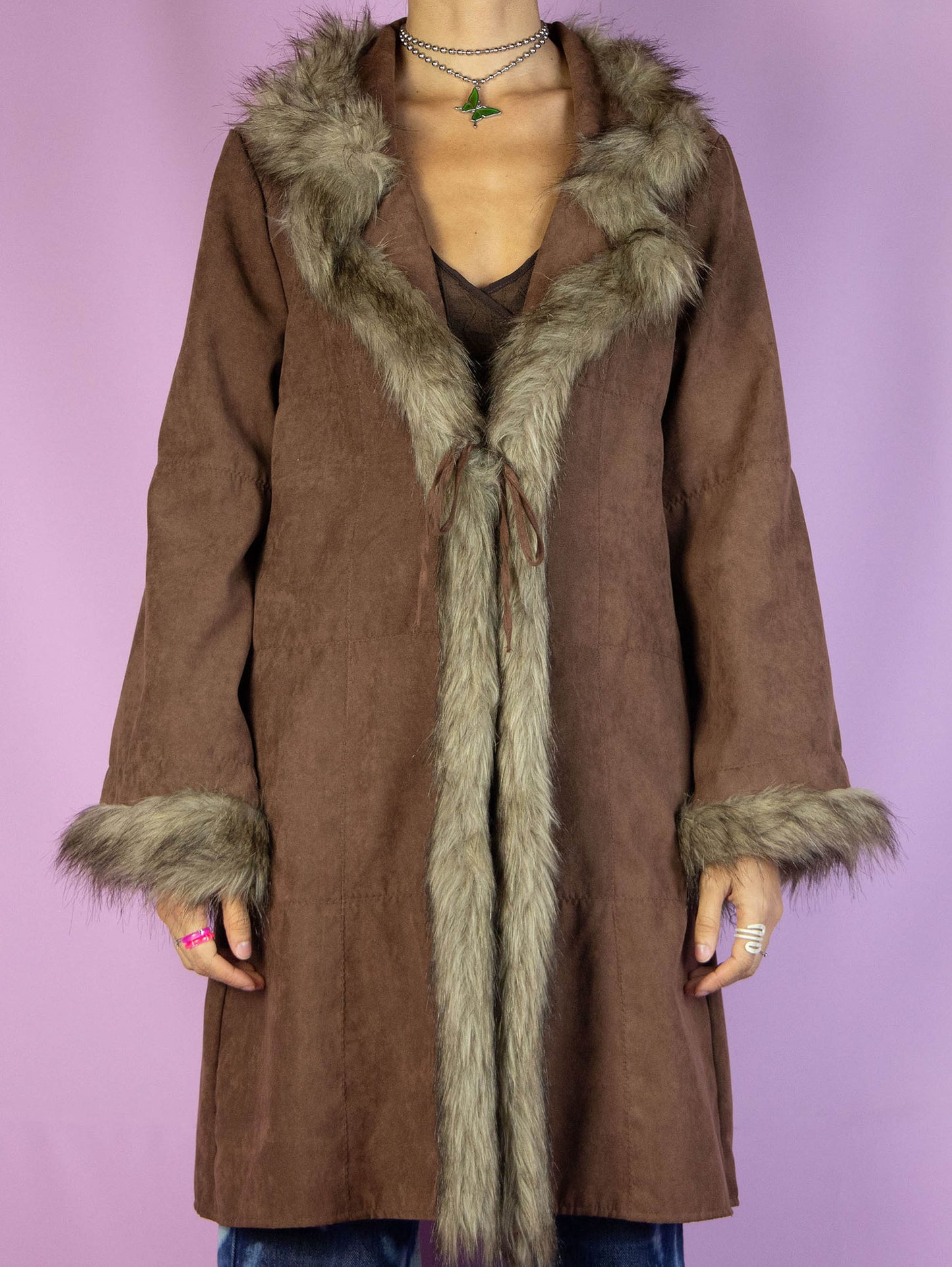 The Y2K Brown Penny Lane Coat is a vintage 2000s afghan-inspired faux suede statement jacket with faux fur collar and cuffs, featuring pockets and a tied front.