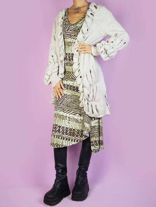 The Y2K Beige Long Cardigan is a vintage 2000s oversized bubble knit open cardigan featuring an intricate cutout design along the edges and sleeves. Perfect for a cozy winter casual outfit.