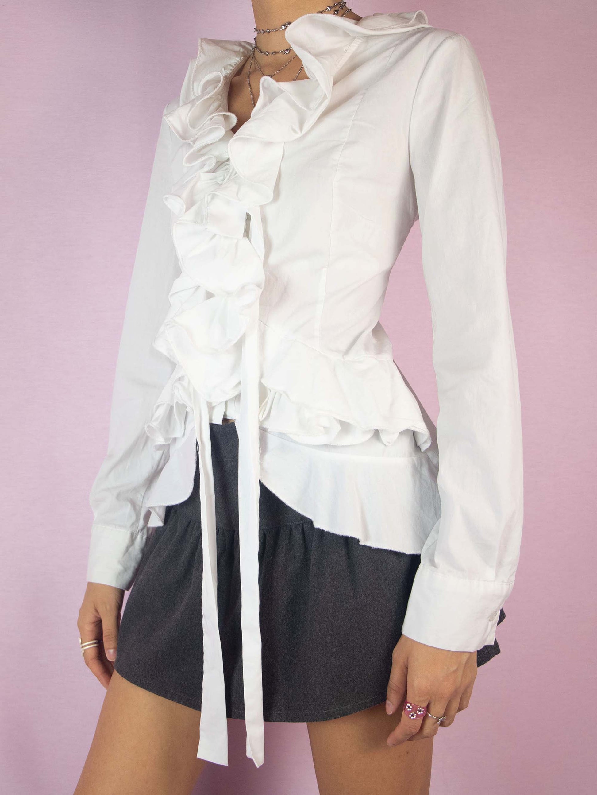 The Y2K White Ruffle Blouse is a tailored vintage 2000s regency victorian inspired shirt with a v-neckline and button closure. Made in Italy.