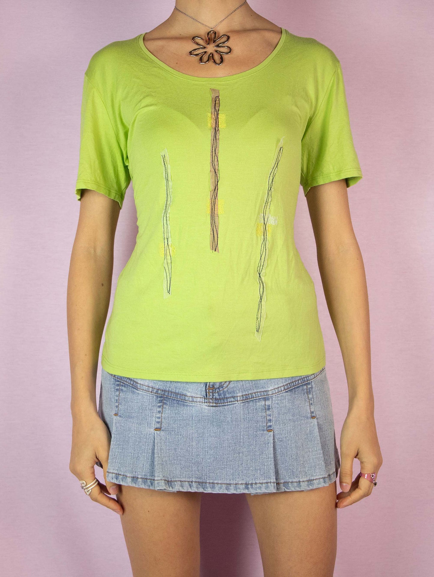 The Y2K Lime Green Tee is a vintage 2000s short-sleeved t-shirt adorned with applique details. Perfect for adding a fun and playful touch to any casual summer outfit. Made in Spain.