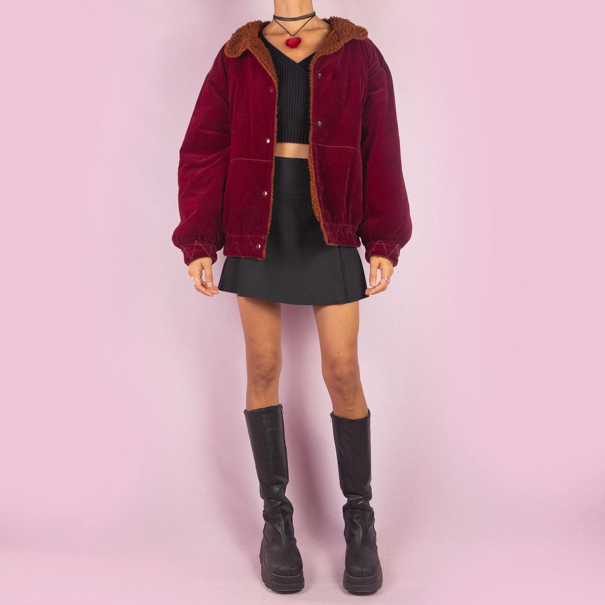 The Vintage 90s Red Velvet Bomber Jacket is a striking piece with a deep red velvet exterior featuring a contrasting brown faux shearling collar and inner lining. It includes snap button closures. Perfect for casual winter days or adding a bold touch to any outfit. Made in Italy.