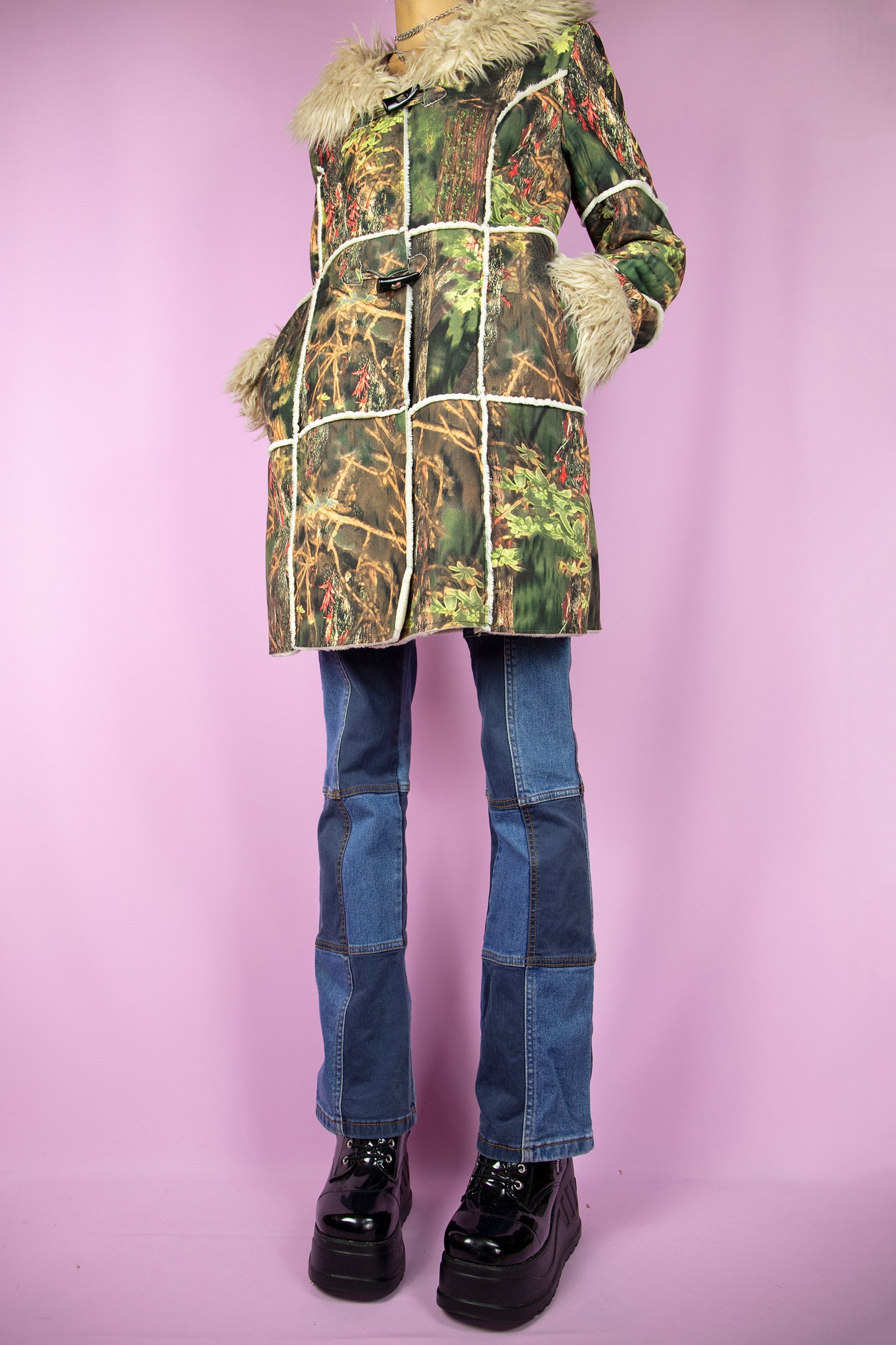 The Y2K Green Penny Lane Coat is a vintage abstract forest graphic printed jacket with beige faux fur collar and cuffs, pockets and toggle closure. Cyber boho 2000s afghan style winter statement coat.