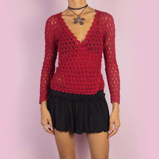 The Y2K Red Crochet Wrap Cardigan is a vintage 2000s piece featuring a romantic deep V-neckline with an intricate open-knit design. Its wrap style and tie closure at the back form a stylish bow, creating a flattering silhouette. Perfect for layering in spring and summer.