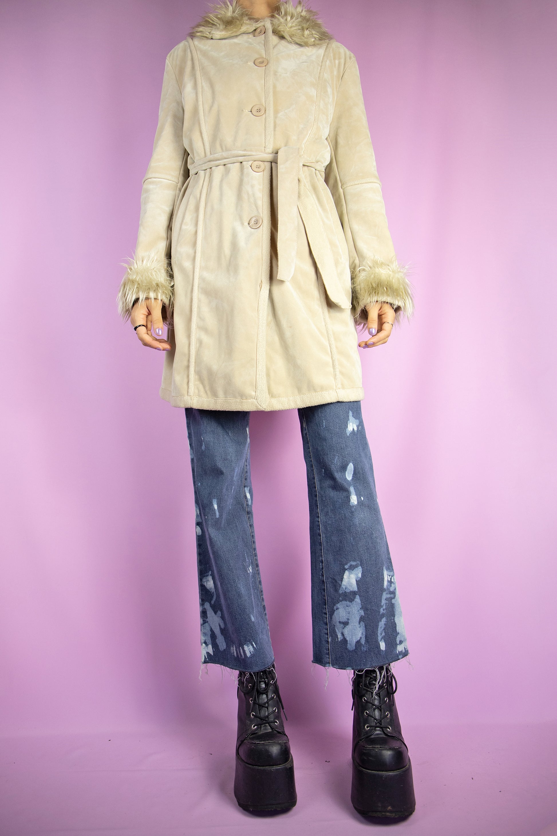 The Y2K Beige Penny Lane Jacket is a vintage 2000s winter faux suede coat featuring a faux fur collar and cuffs, pockets, buttons, and a coordinating belt. Iconic in style, it’s perfect for both casual wear and party outfits.