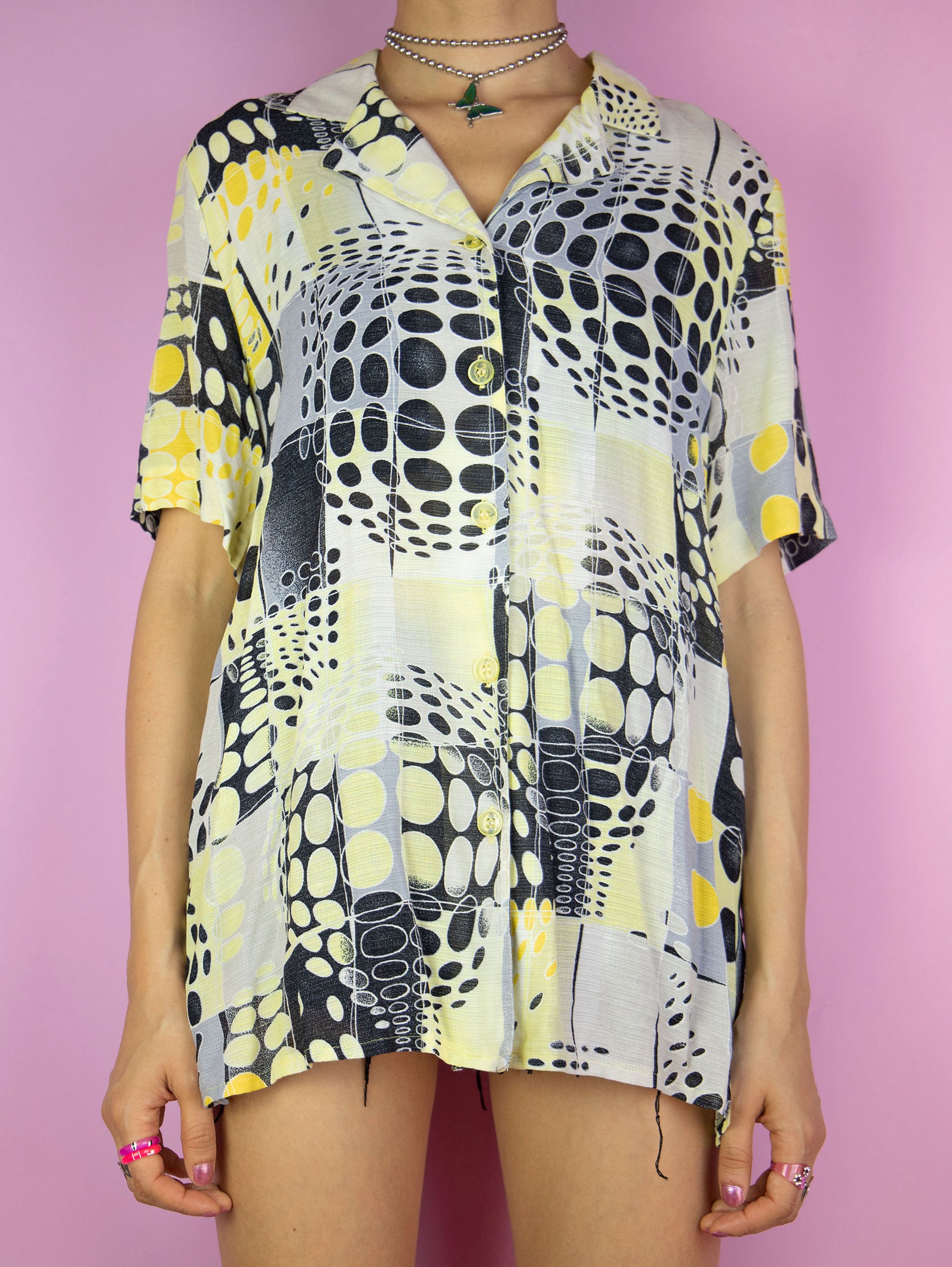The Vintage 90s Abstract Print Shirt is a summer festival style yellow, black and white short sleeve geometric crazy pattern collared blouse with button closure.