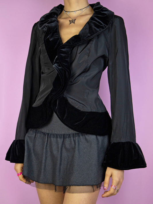The Vintage 90s Black Ruffle Jacket is an elegant piece featuring velvet ruffles around the neckline and cuffs, along with a front hook closure. Perfect for a whimsical evening, party, or night-out outfit.