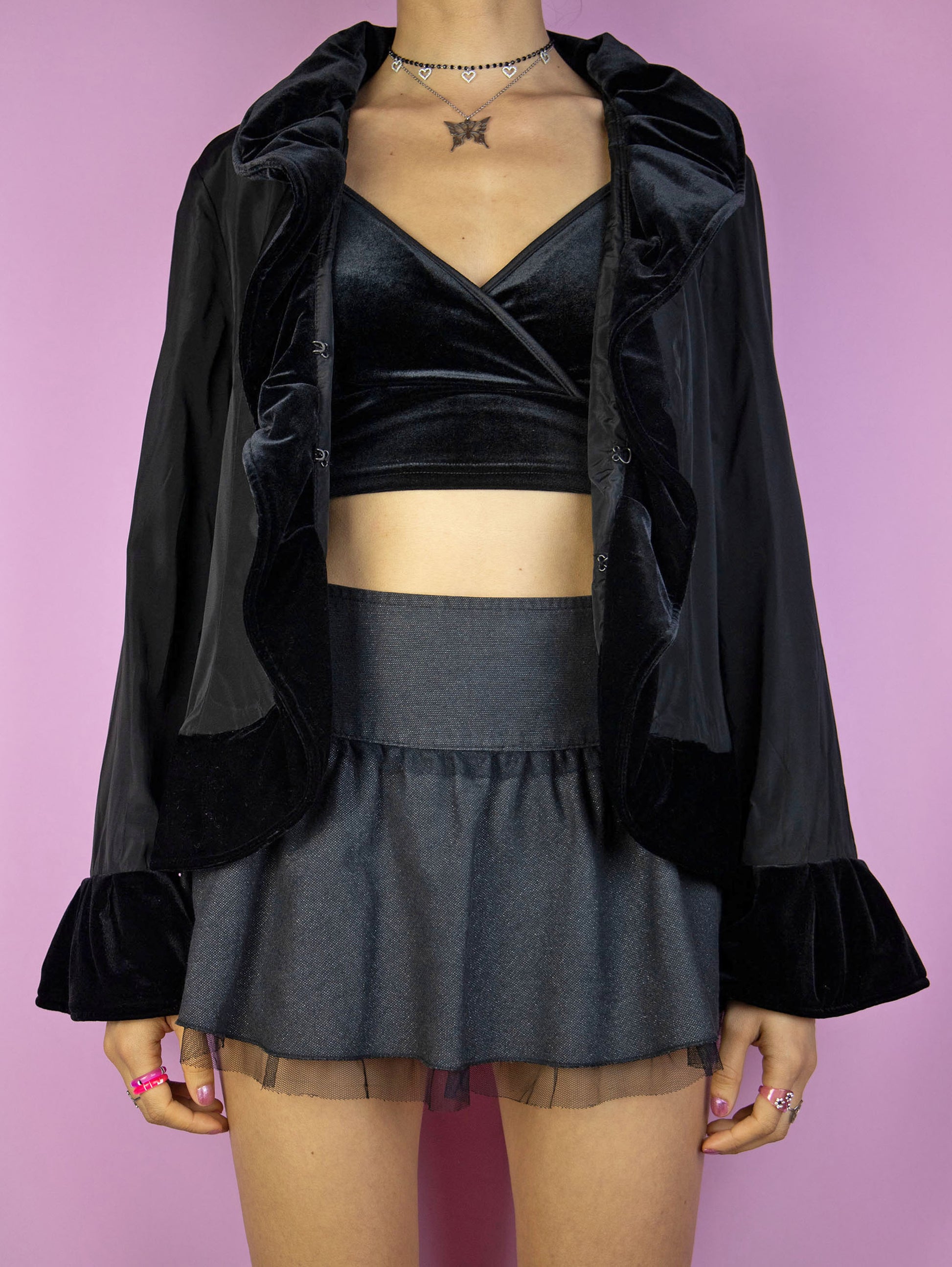 The Vintage 90s Black Ruffle Jacket is an elegant, romantic, whimsygoth-inspired statement piece, featuring velvet ruffle details and a front hook closure.