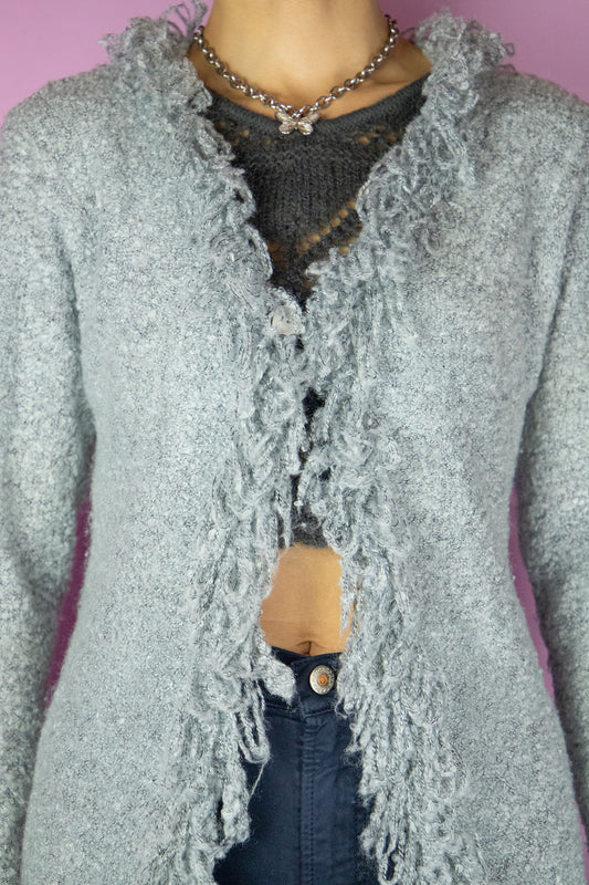 The Y2K Gray Penny Lane Cardigan is a vintage long shaggy knit cardigan with a one button closure and fringe trim at the neckline and cuffs. Cyber fairy grunge 2000s boho duster jacket.