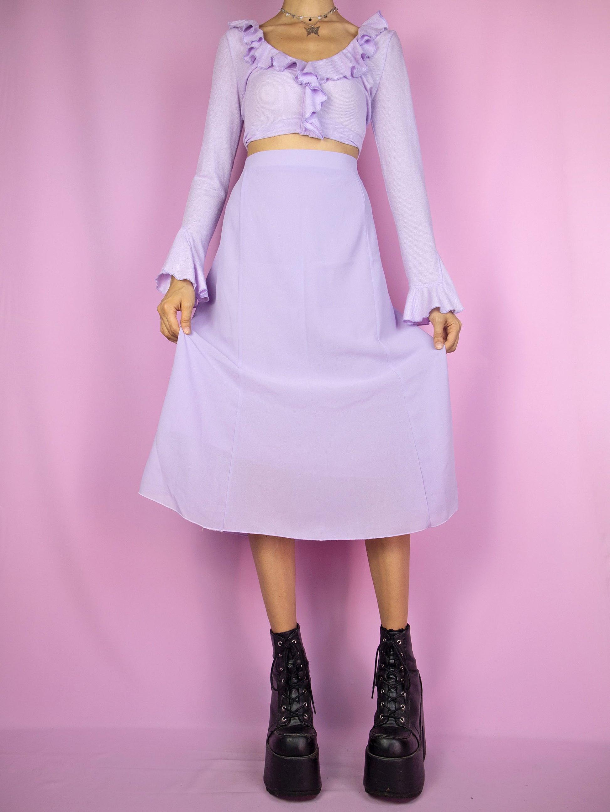 The Y2K Purple Trumpet Midi Skirt is a vintage 2000s pastel light lilac skirt featuring a side zipper closure. With a boho and romantic design, it's perfect for a casual summer outfit.