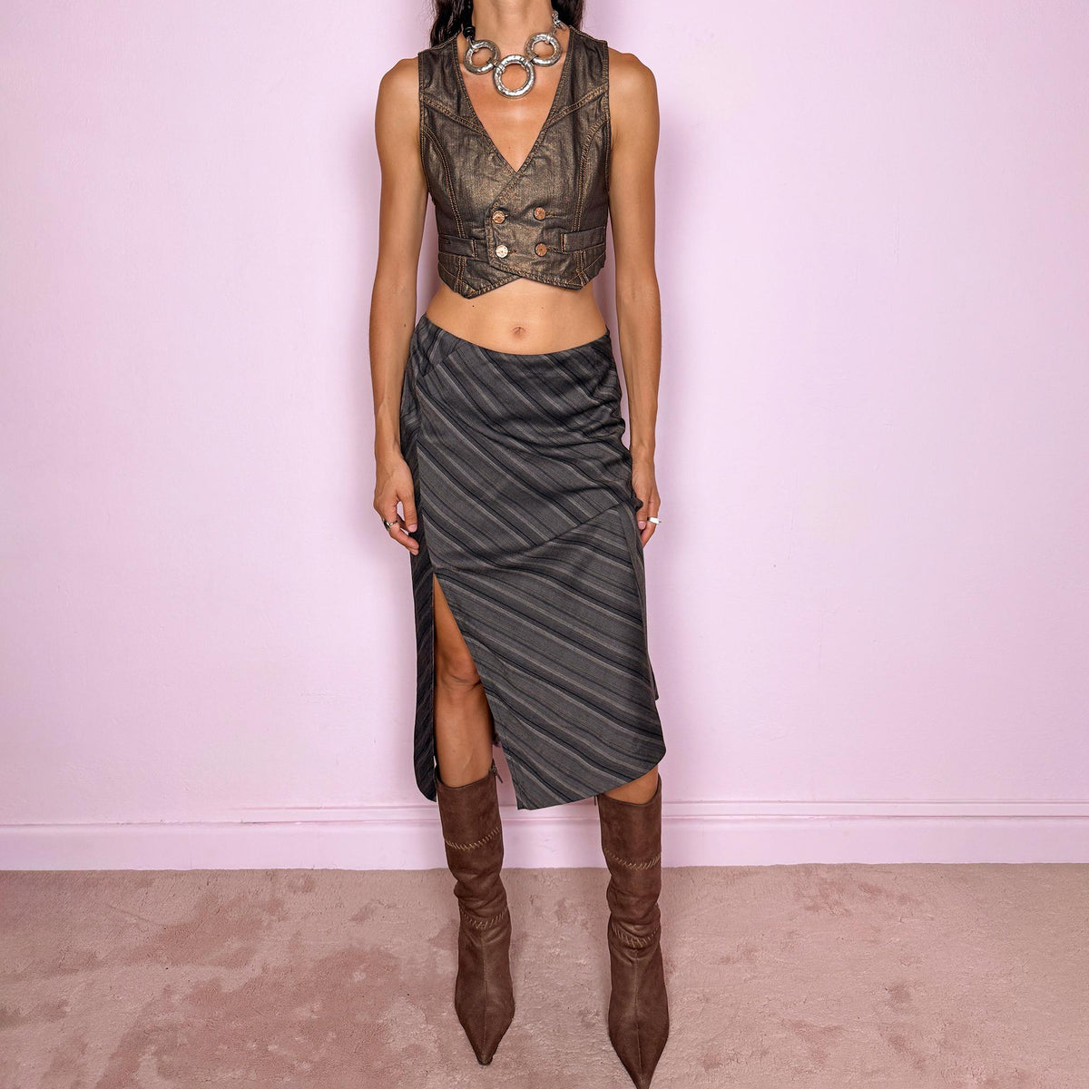 Vintage 2000s brownish-gray striped midi skirt by Kenzo Jungle, featuring diagonal stripe placement, a side slit, and a side zip closure. The muted brown-gray palette and refined tailoring give it a sophisticated, minimalist designer aesthetic. Can be worn mid-rise for size M. Crafted from a non-stretch blend of 58% viscose, 30% wool, 9% mohair, and 3% elastane, with a 100% polyester lining. Excellent vintage condition.
