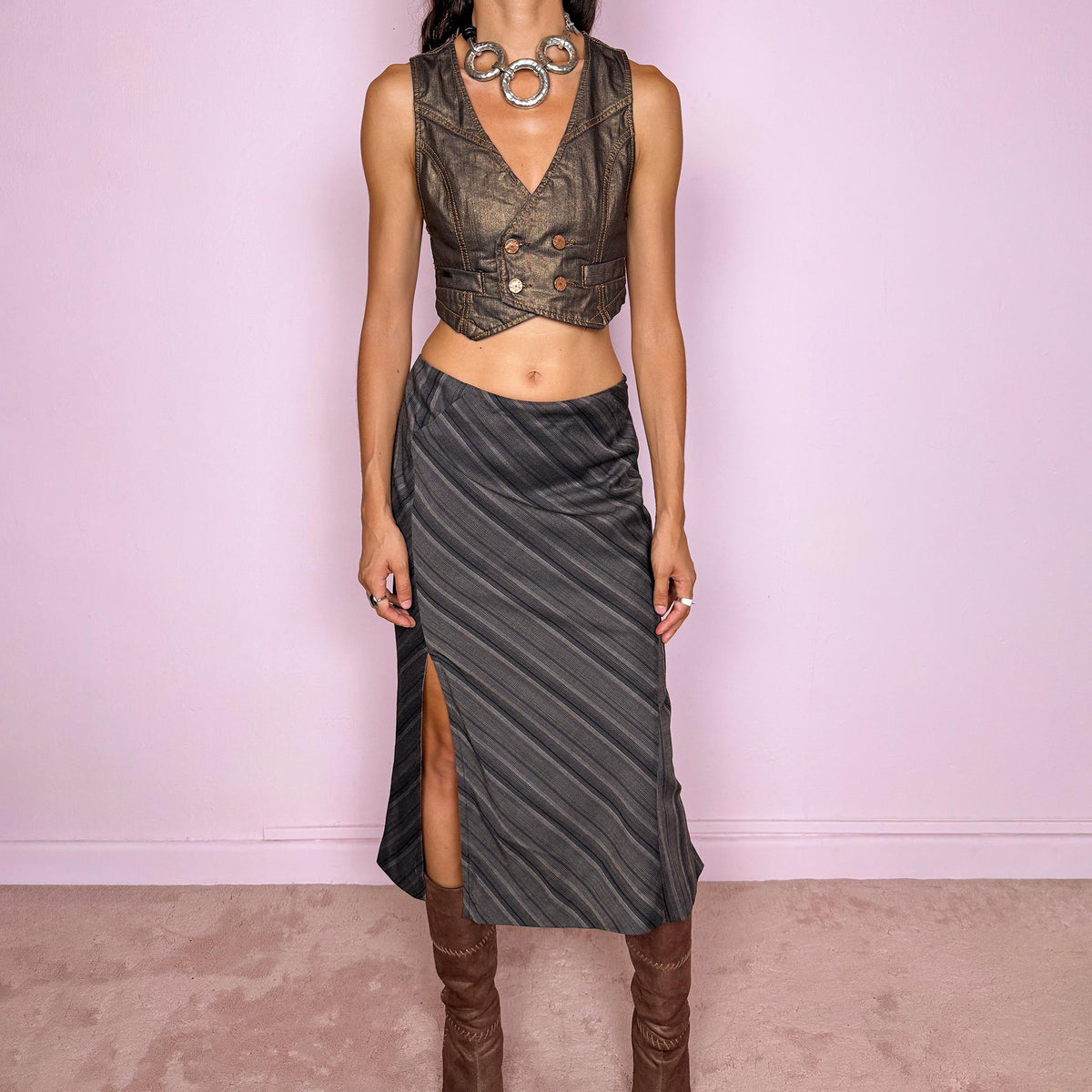 Vintage 2000s brownish-gray striped midi skirt by Kenzo Jungle, featuring diagonal stripe placement, a side slit, and a side zip closure. The muted brown-gray palette and refined tailoring give it a sophisticated, minimalist designer aesthetic. Can be worn mid-rise for size M. Crafted from a non-stretch blend of 58% viscose, 30% wool, 9% mohair, and 3% elastane, with a 100% polyester lining. Excellent vintage condition.