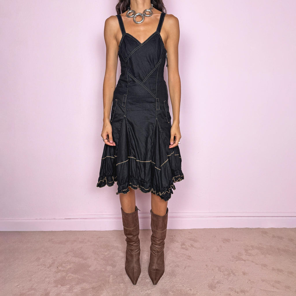 Vintage 2000s black linen midi dress by French designer label Marithé + François Girbaud, made from 100% non-stretch linen. Features adjustable shoulder straps with snap-button fastenings, a fitted paneled bodice, contrast topstitching, a side zip closure, and pockets. The skirt flares into a sculptural asymmetric hem with gathered sections and ruffled edges. Excellent vintage condition.